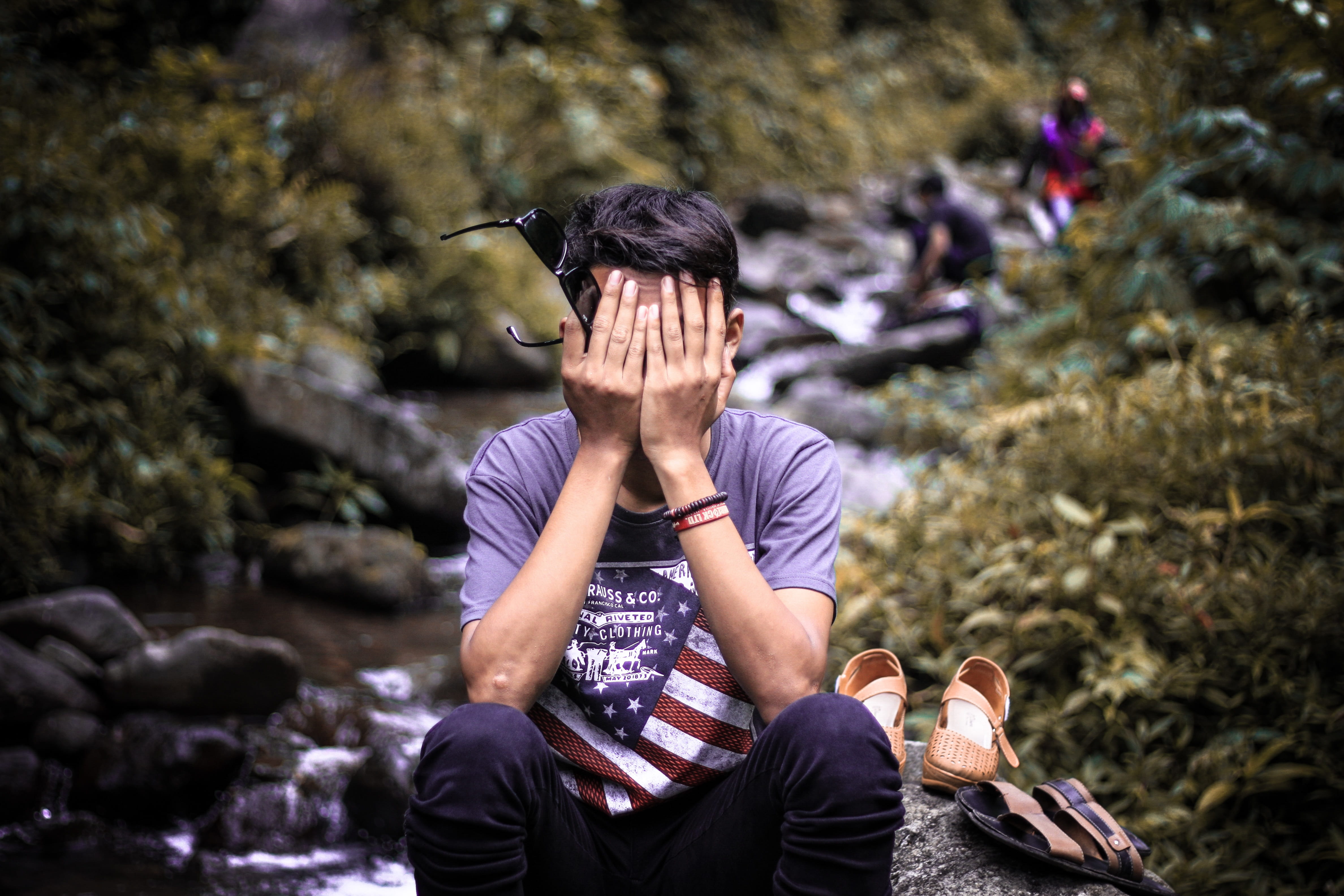 lifestyles, young adult, rock, men, outdoors, rock - object, sitting, leisure activity, facepalm, day, forget, focus on foreground, young, front view, three quarter length, HD Wallpaper