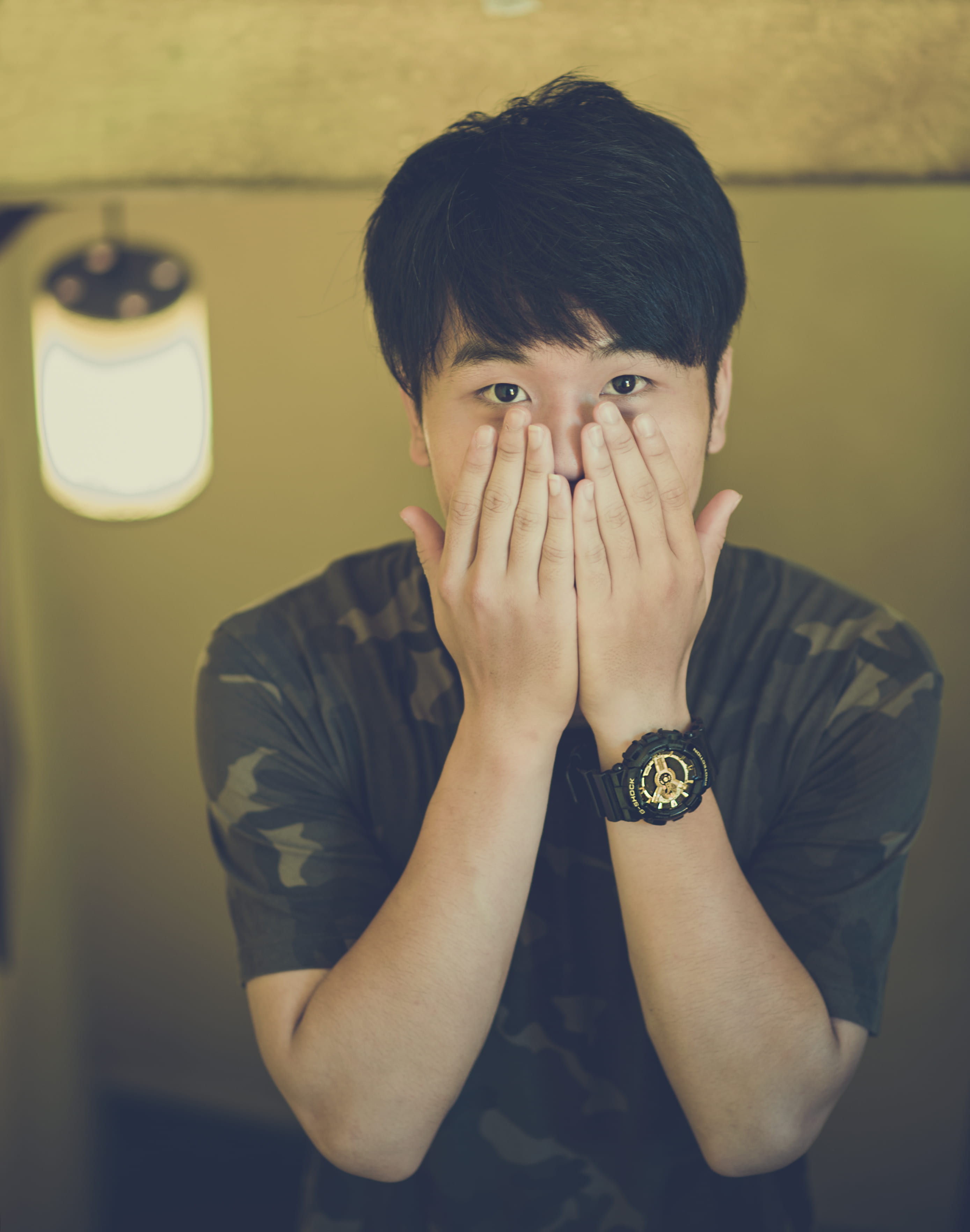 adult, obscured face, real people, indoors, eyes, t, wearing, Asian, shirt, crew, watch, standing, head in hands, hand, wear, facial expression, waist up, Phone HD Wallpaper