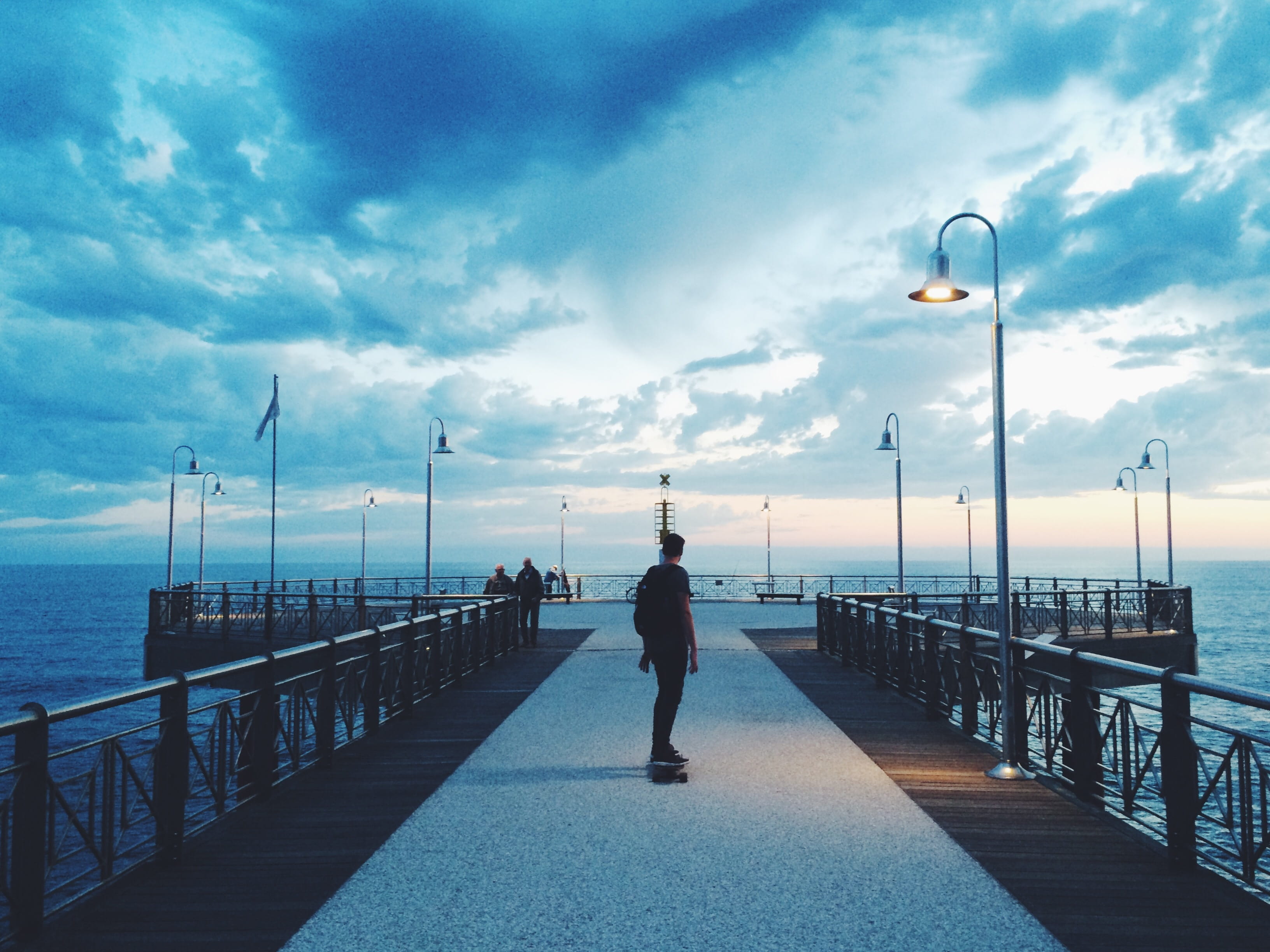 outdoors, t-shirt, rear view, street light, pier, leisure activity, shirt, lighting equipment, riding, black, man, sky, men, lifestyles, promenade, 2K, HD Wallpaper
