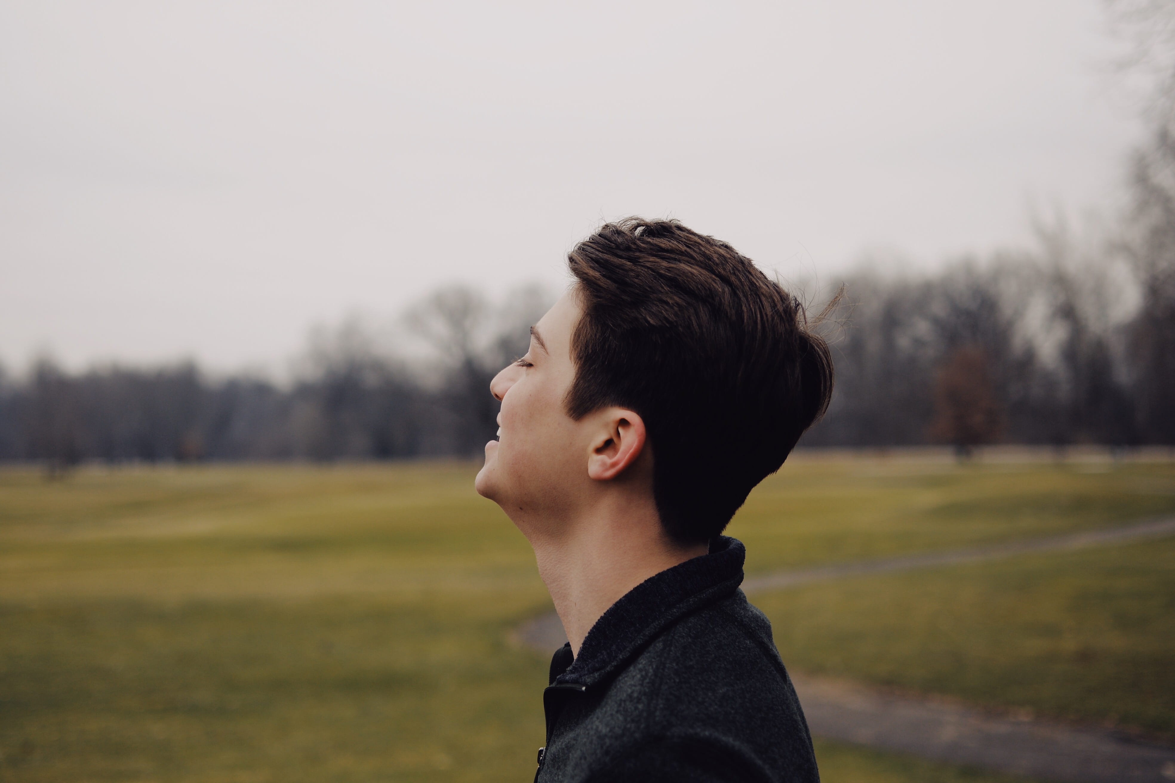 teenager, casual clothing, tree, lifestyles, young adult, field, grass, smiling, side view, human, focus on foreground, looking away, child, boy, profile view, HD Wallpaper