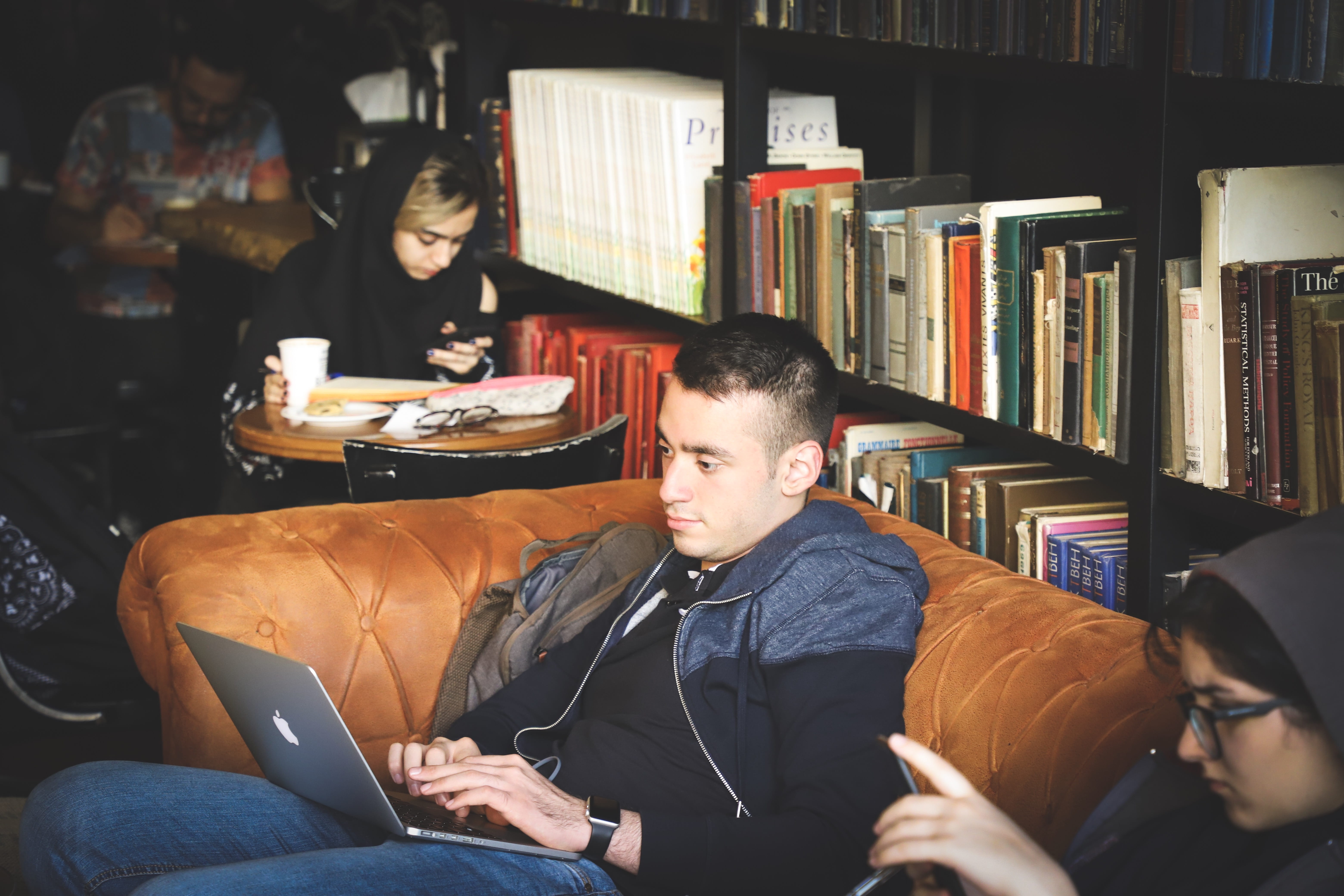 looking, couch, wooden, black, book, lifestyles, silver, bookshelf, leisure activity, working, 5K, tufted, young adult, men, publication, sitting, people, HD Wallpaper