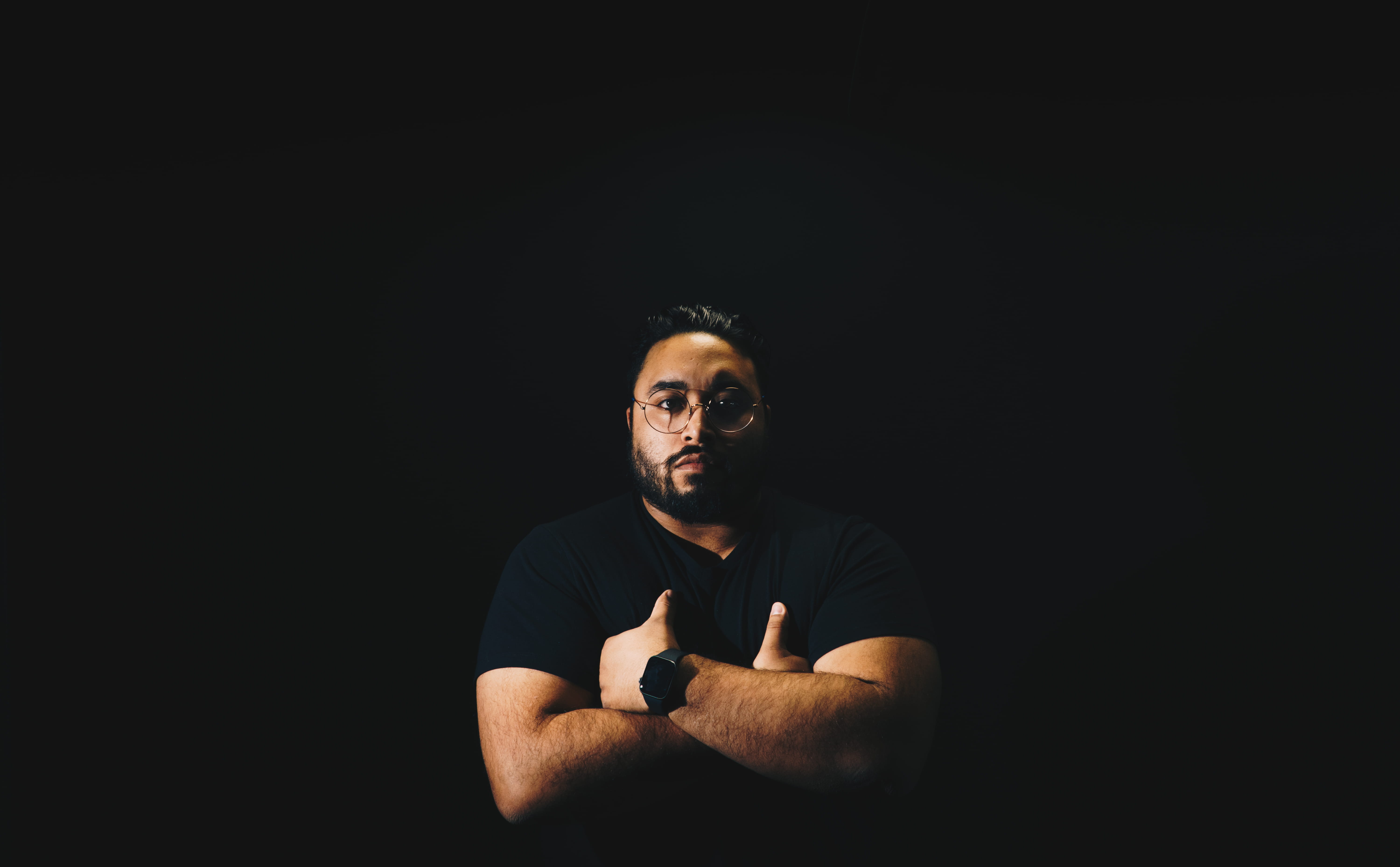 clothing, dark, photo, black background, latino, serious, beard, shirt, facial hair, crew, crosses, person, black, young adult, sitting, apparel, sleeve, HD Wallpaper
