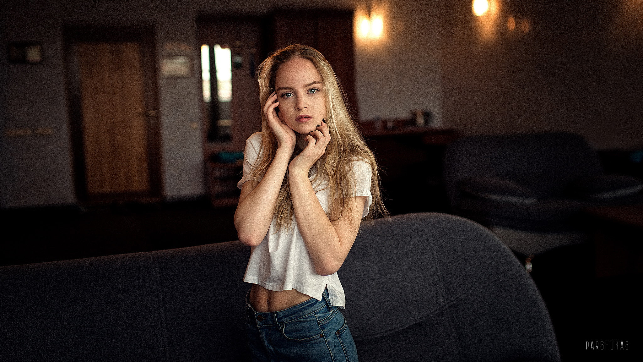 denim, hand on face, looking at viewer, blue eyes, women, jeans, 1080P, white shirt, blonde, couch, Anton Parshunas, touching face, HD Wallpaper