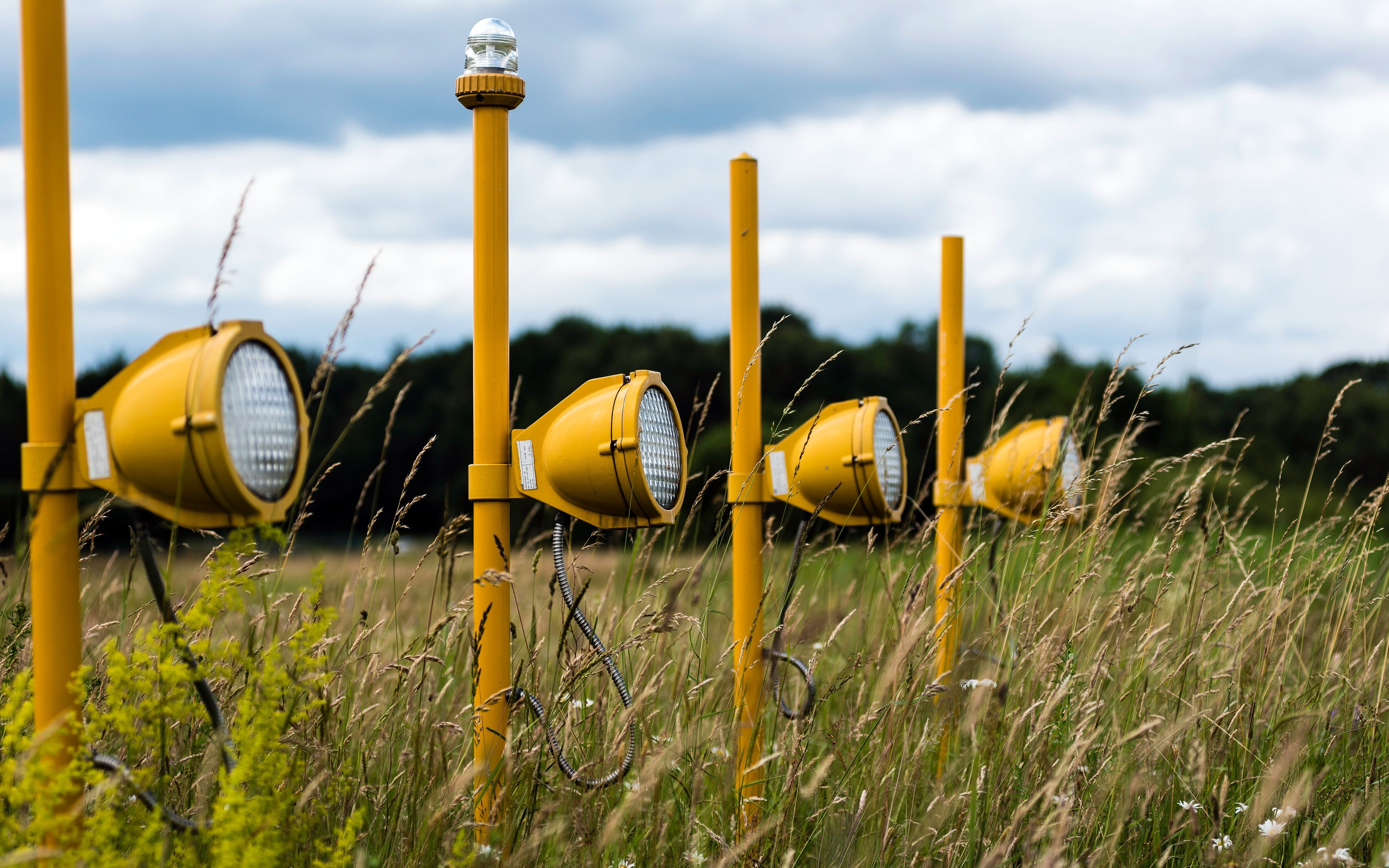 searchlight, selective focus, cloud - sky, in a row, focus on foreground, grassland, lighting equipment, sky, no people, land, plant, outdoors, yellow, HD Wallpaper