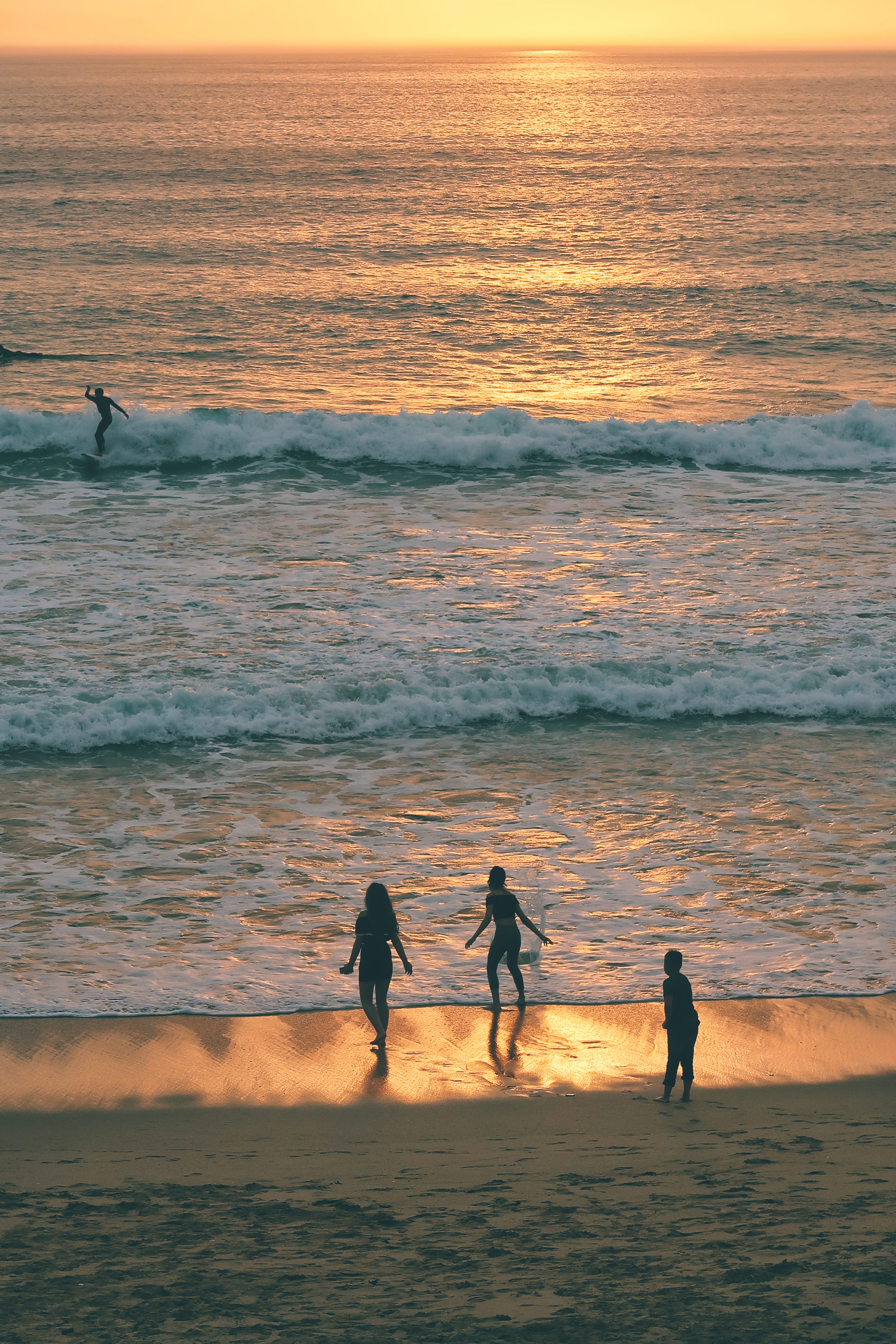 ocean, fistral beach, sky, orange color, three, group of people, wave, silhouette, togetherness, 5K, leisure activity, coast, horizon over water, scenics - nature, Phone HD Wallpaper