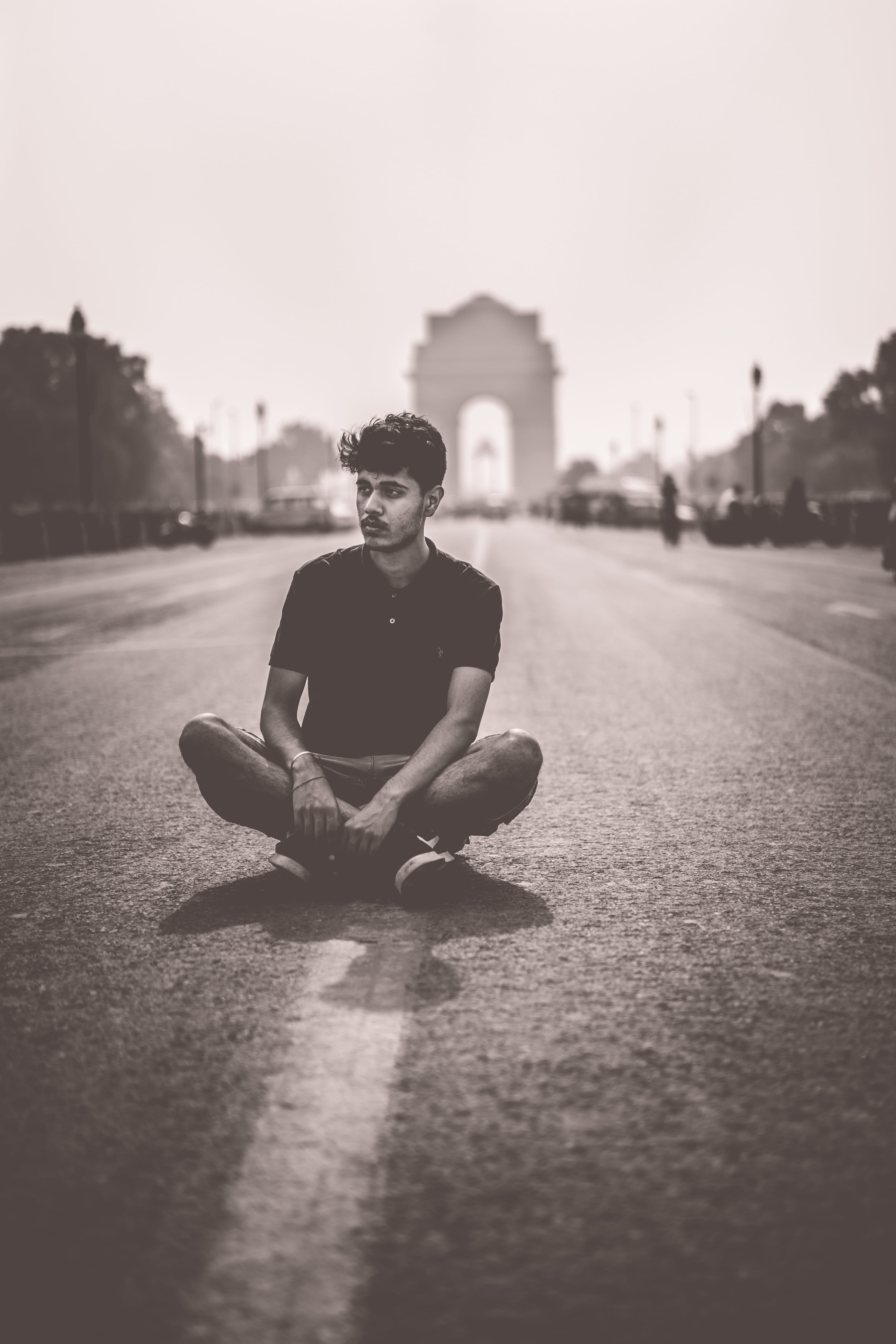 young adult, looking at camera, surface level, sky, architecture, travel, cross-legged, india, leisure activity, path, black and white, man, asphalt, city, Phone HD Wallpaper