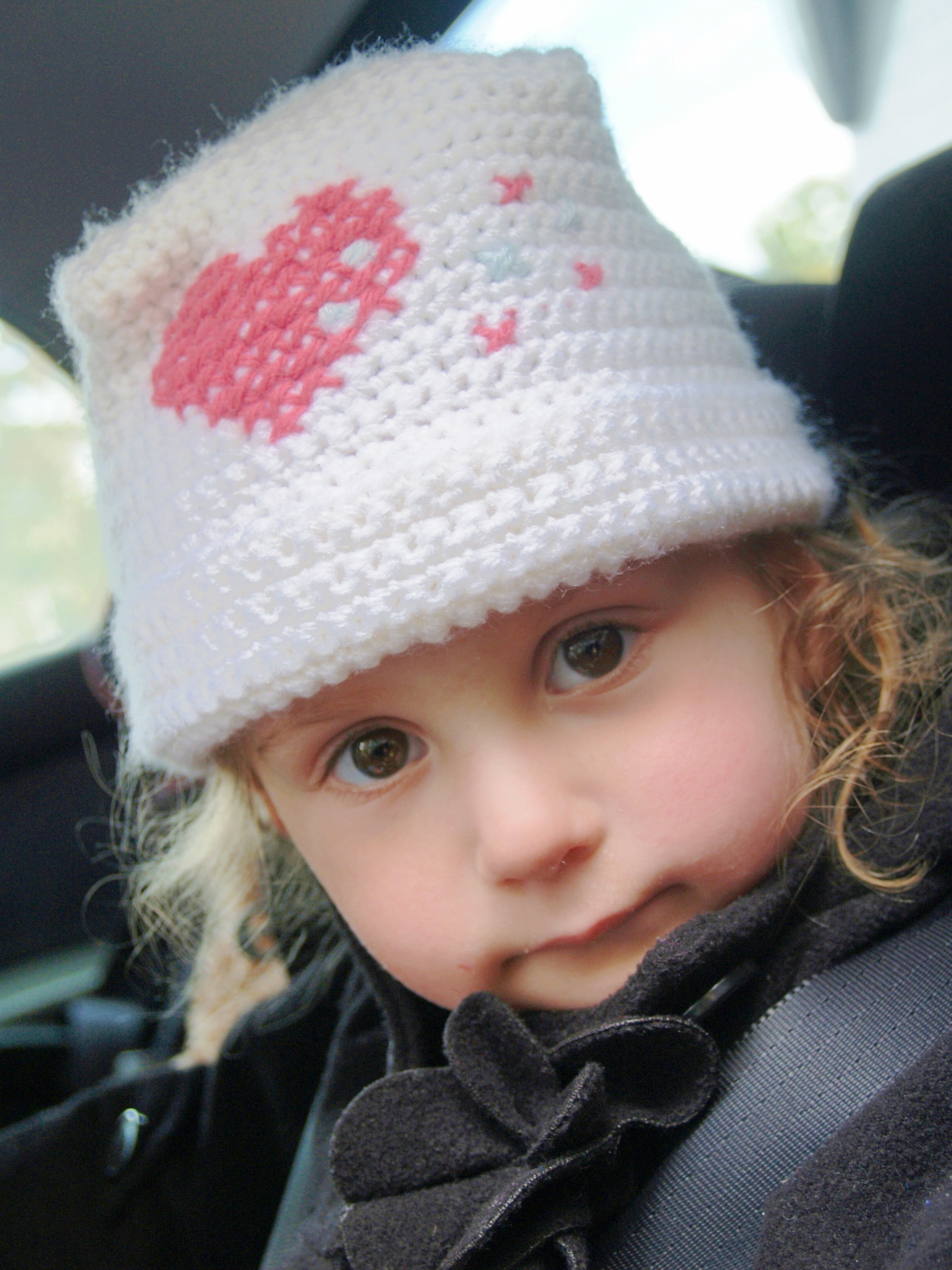 sitting, kid, crochet, child, daughter, clothing, human face, day, headshot, portrait, looking at camera, little girl, solemn, hat, expression, heart, car seat, Phone HD Wallpaper