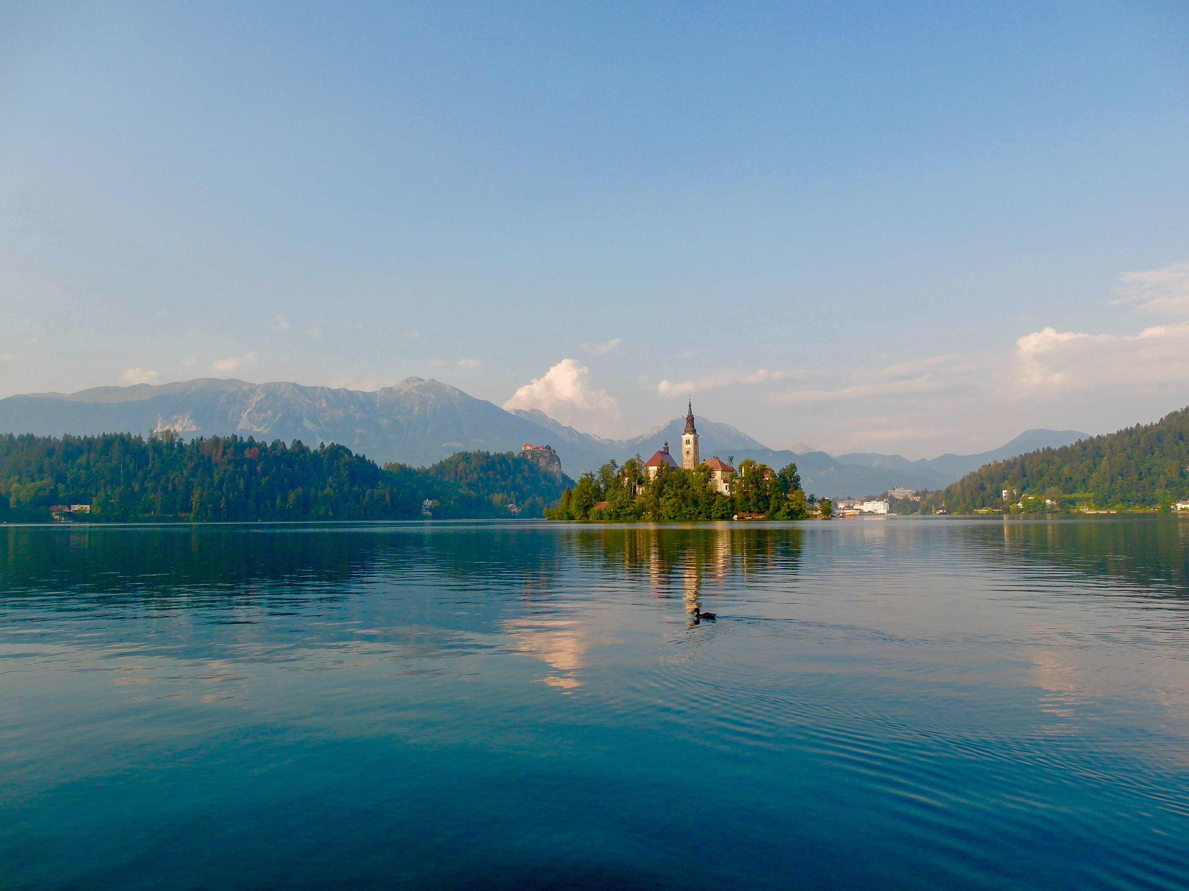 waterfront, island, bled, mountain range, promontory, beach, lagoon, day, 4K, mountain, ocean, water, lake, church, outdoors, vegetation, tranquil scene, HD Wallpaper