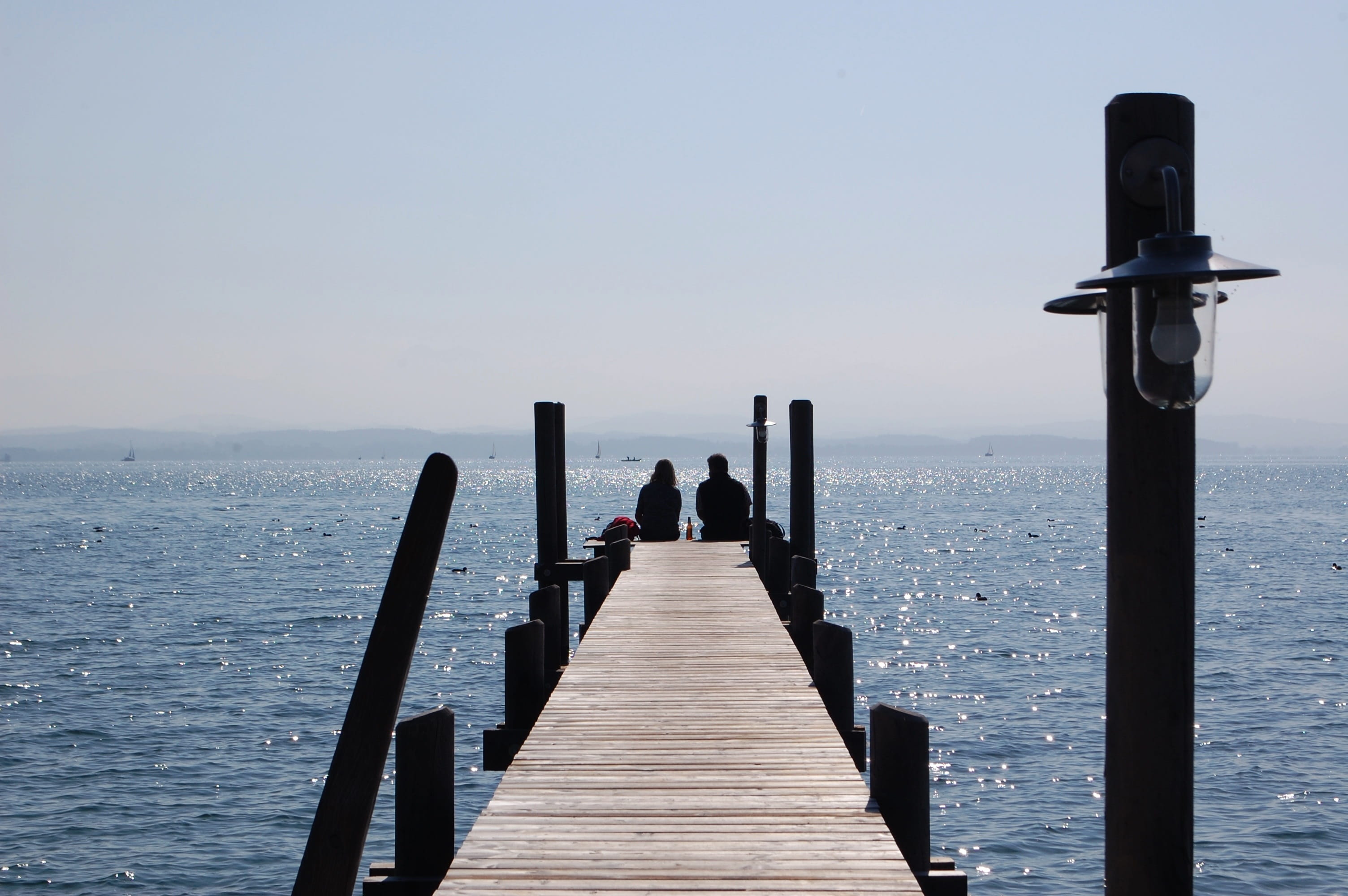 coast, outdoors, real people, 2K, wood, lake, horizon, direction, long, shadow, water, rear view, nature, chiemsee, sea bridge, women, pair, wood - material, HD Wallpaper