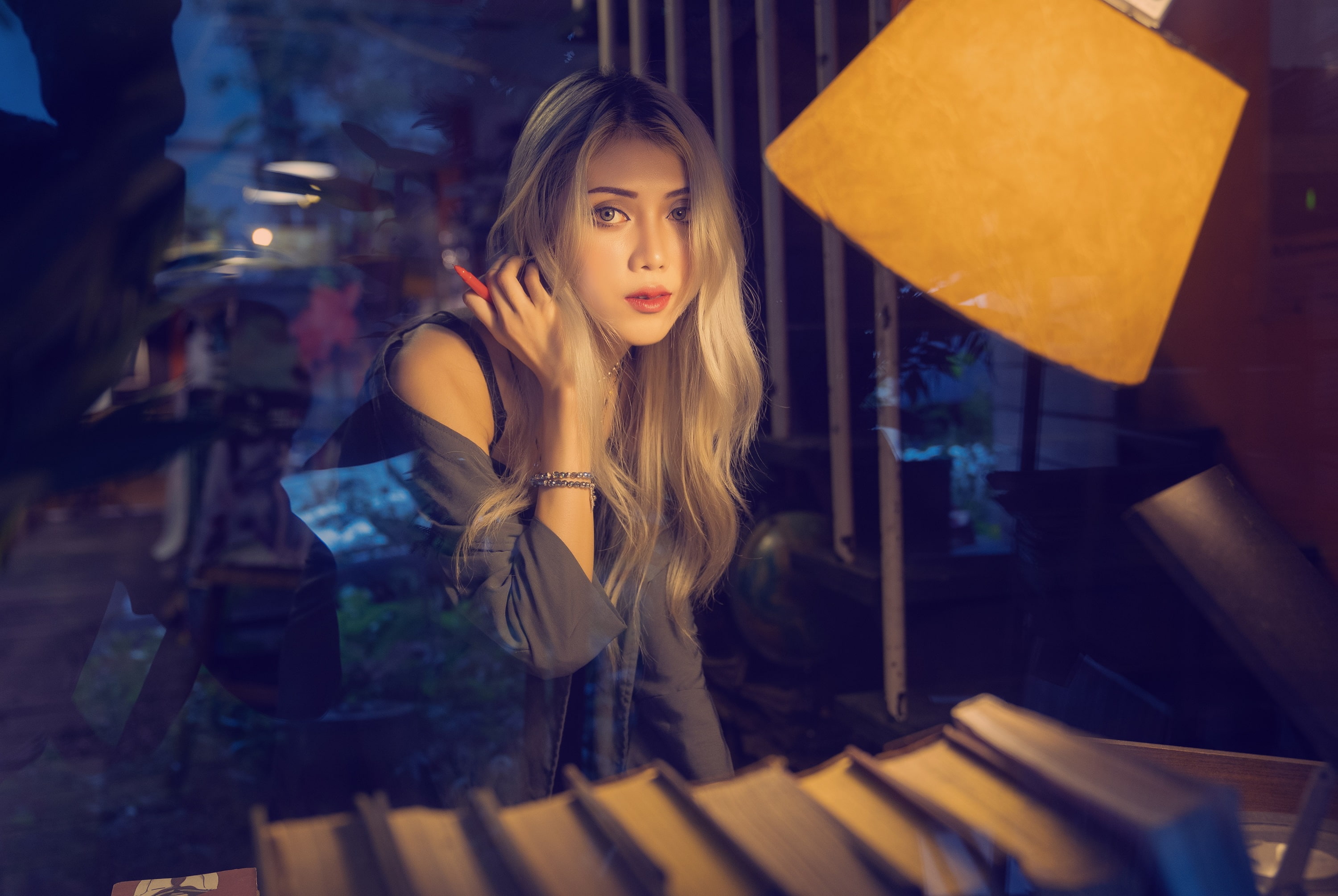 women, blonde, portrait, books, model, Asian, indoors, glass, depth of field, 2K, women indoors, lamp, looking at viewer, HD Wallpaper