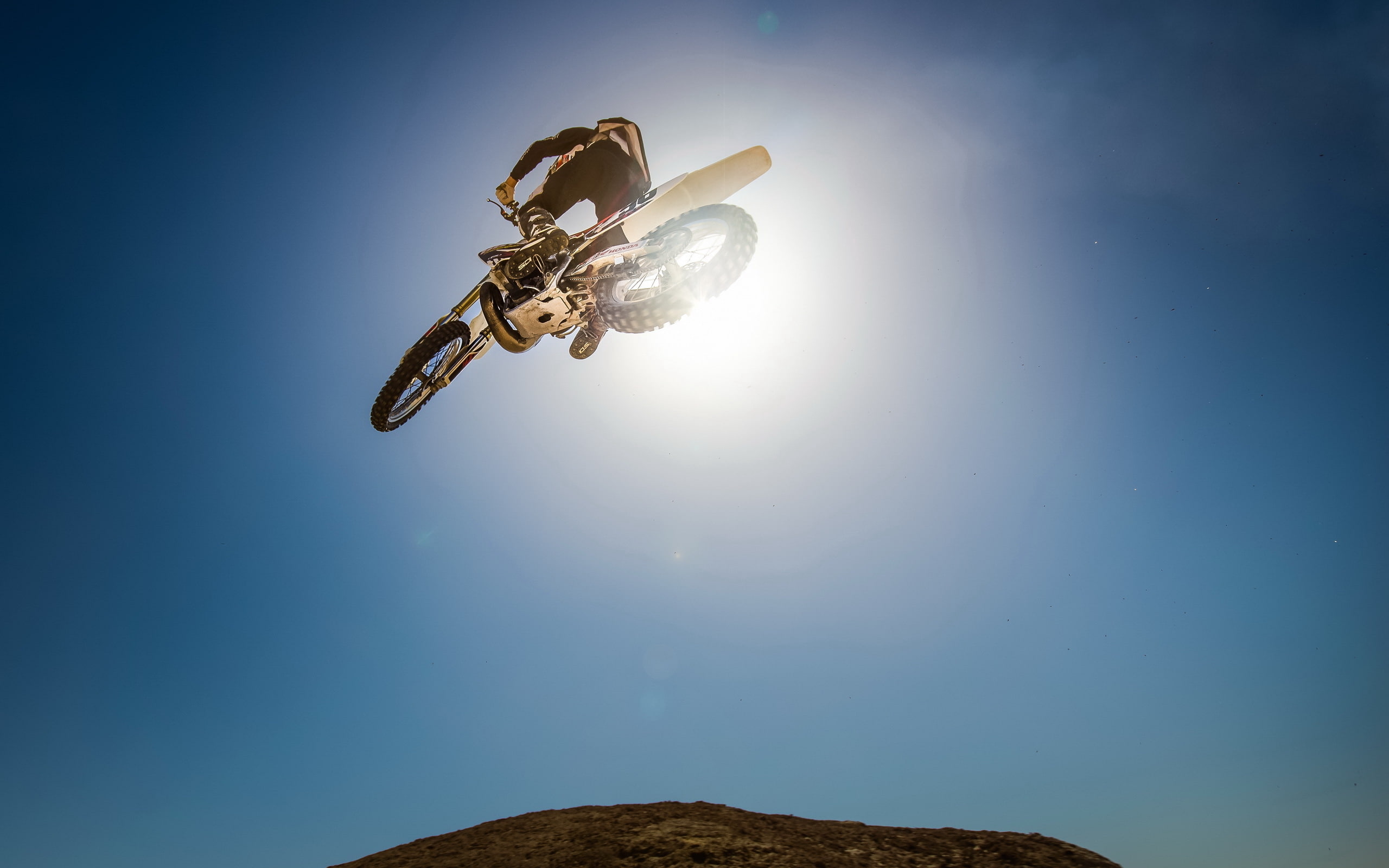 motion, mid-air, day, clear sky, sun, no people, sunny, drone, lens flare, sky, Motorcycle stunt, sunlight, blue, flying, 2K, low angle view, nature, futuristic, HD Wallpaper