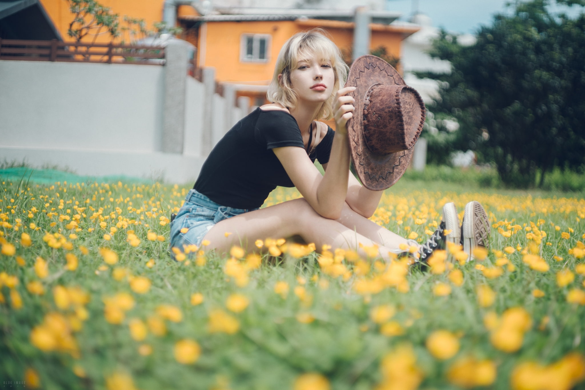 jean shorts, women with hats, black tops, 1080P, looking at viewer, women, model, women outdoors, sitting, Converse, portrait, yellow flowers, flowers, HD Wallpaper