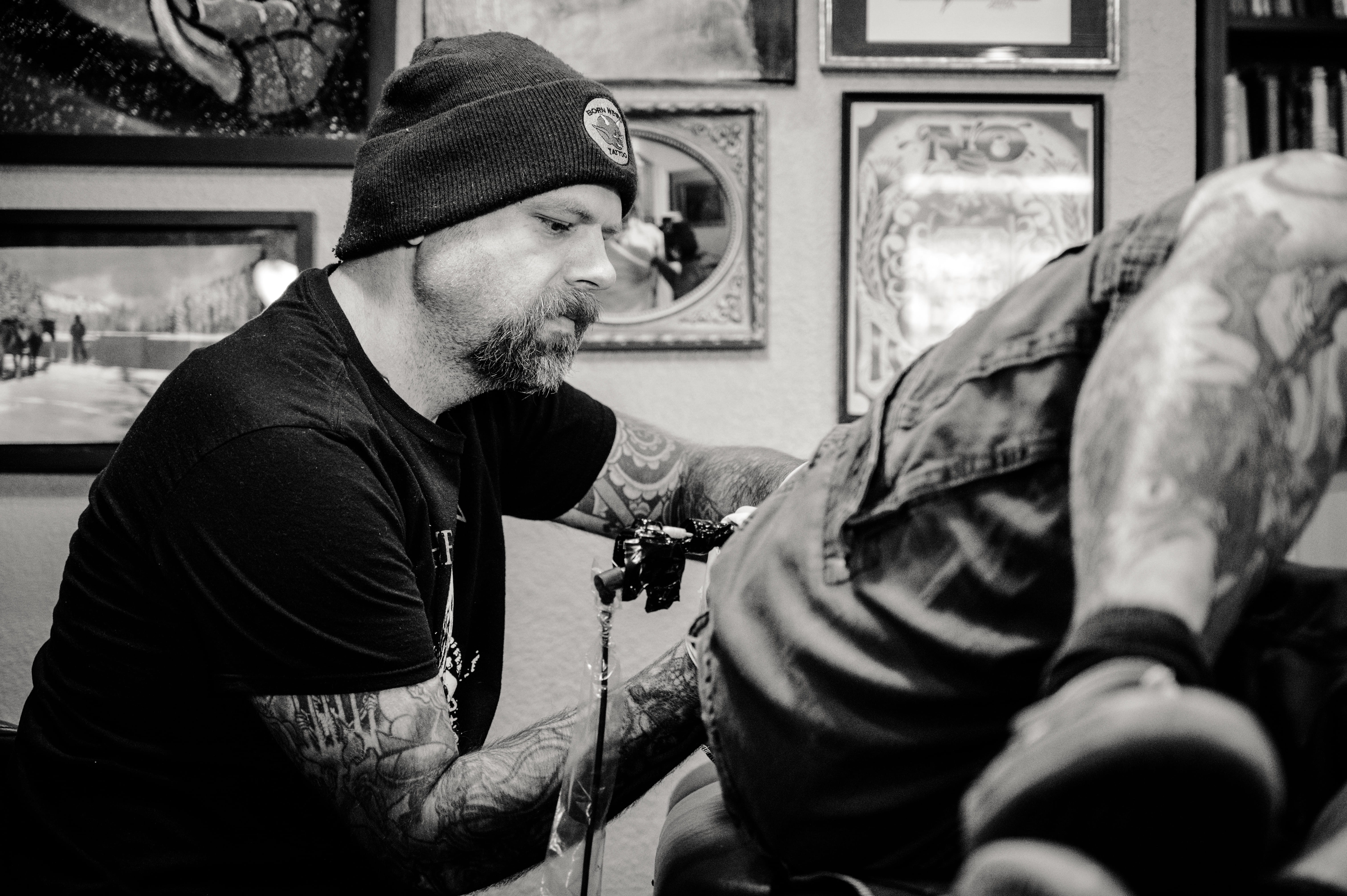 mid adult, one person, cap, another, lifestyles, clothing, person, sit, artist, adult, day, tattoo artist, real people, beanie, recreation, black-and-white, HD Wallpaper