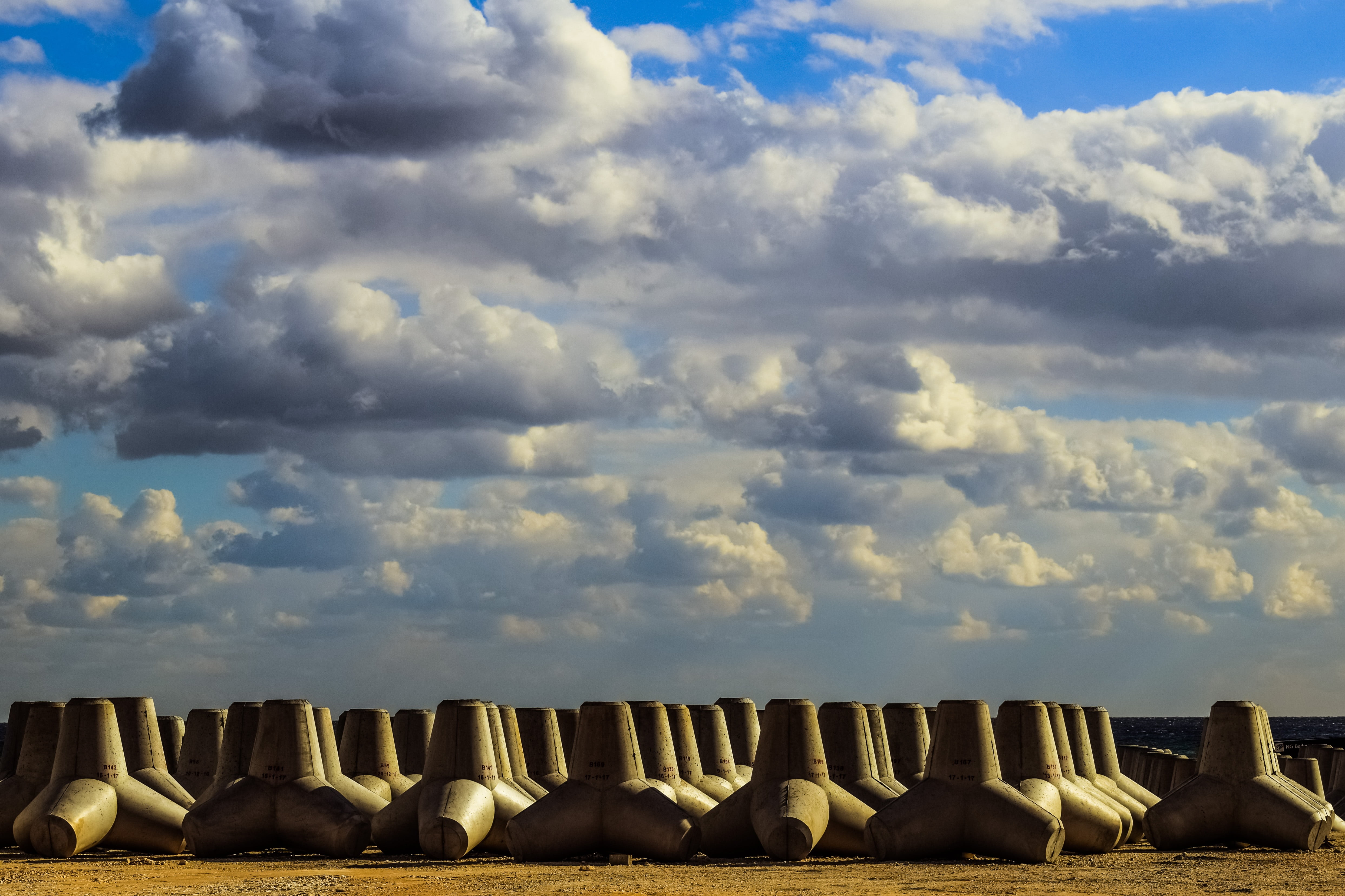 outdoors, in a row, tranquil scene, travel destinations, wave breakers, barrier, concrete, cloud - sky, side by side, abundance, sunlight, clouds, tetrapod, HD Wallpaper