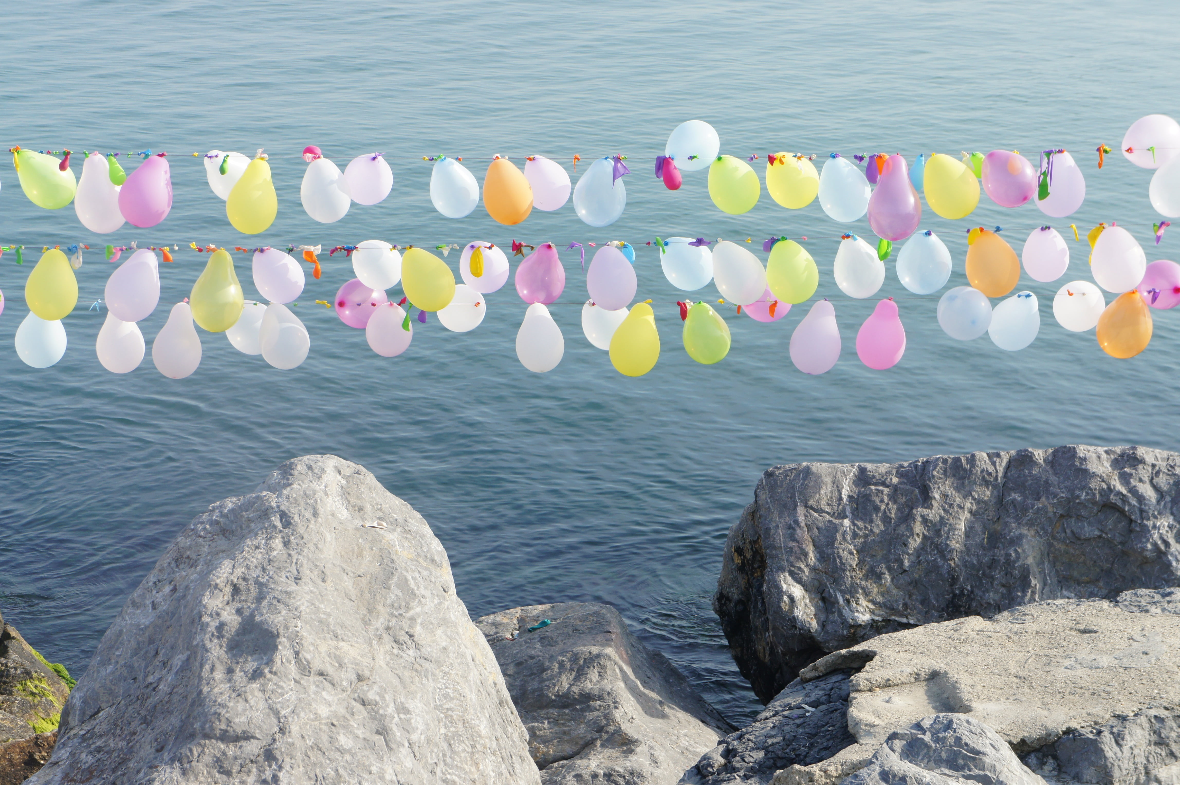 rock - object, rock, balloon, edge, sunlight, day, quay, large group of objects, embankment, celebration, event, summer, hanging, tranquility, land, color, HD Wallpaper