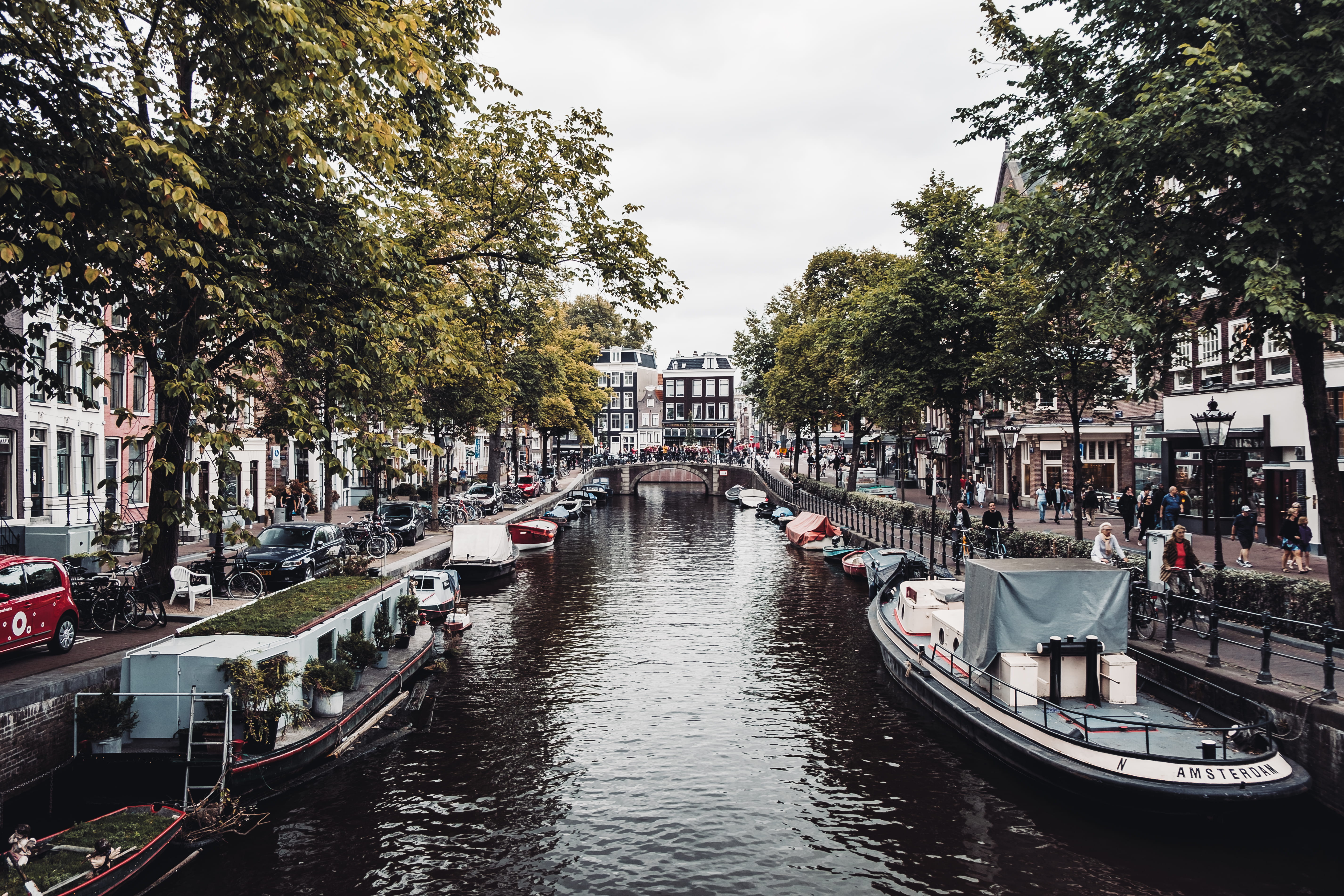 nautical vessel, amsterdam, incidental people, netherlands, city, boat, canal, boats, waterfront, harbor, building, pier, port, transportation, tree, mode of transportation, HD Wallpaper