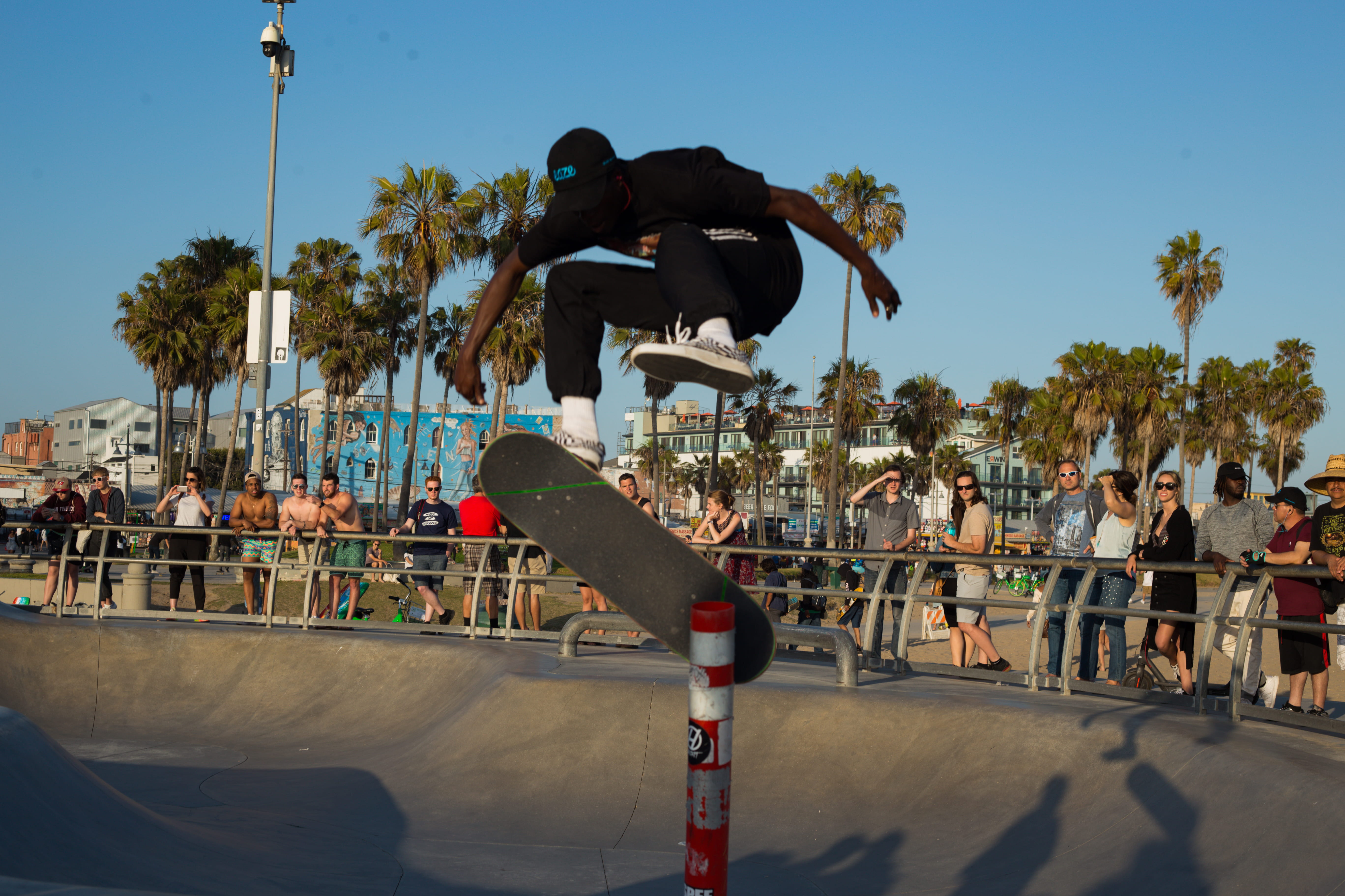 kick, flip, cone, clear sky, crowd, leisure activity, sport, real people, tree, built structure, black, palm tree, group of people, sunlight, plant, jump, HD Wallpaper