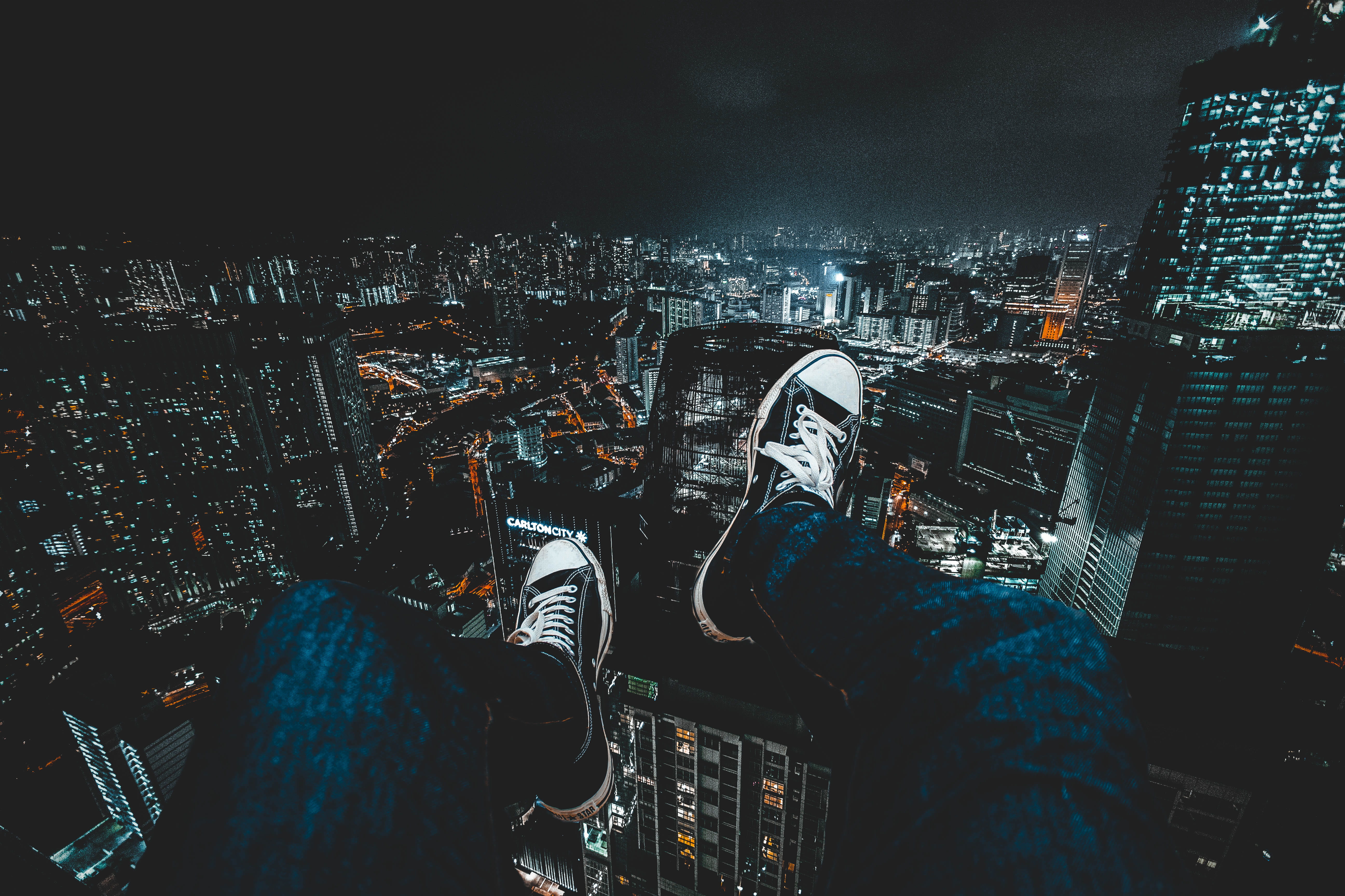 helicopter, lifestyles, architecture, person, modern, wearing, nighttime, blue, sneakers, men, city at night, outdoors, city, feet hanging down, built structure, HD Wallpaper
