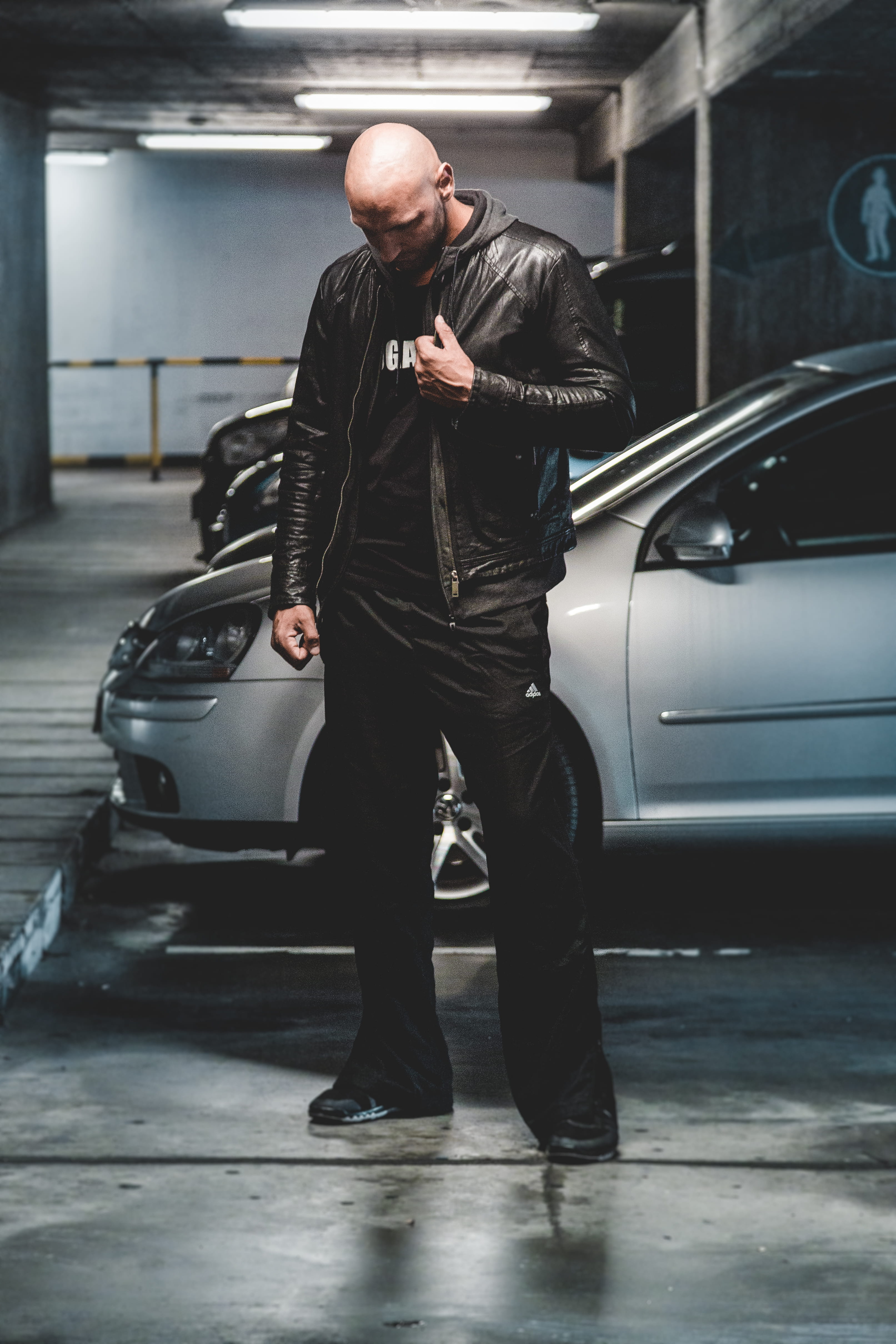 real people, car, jacket, man, automobiles, cars, clothing, guy, black, standing, gray, black leather jacket, indoors, transportation, lights, transportation system, Phone HD Wallpaper