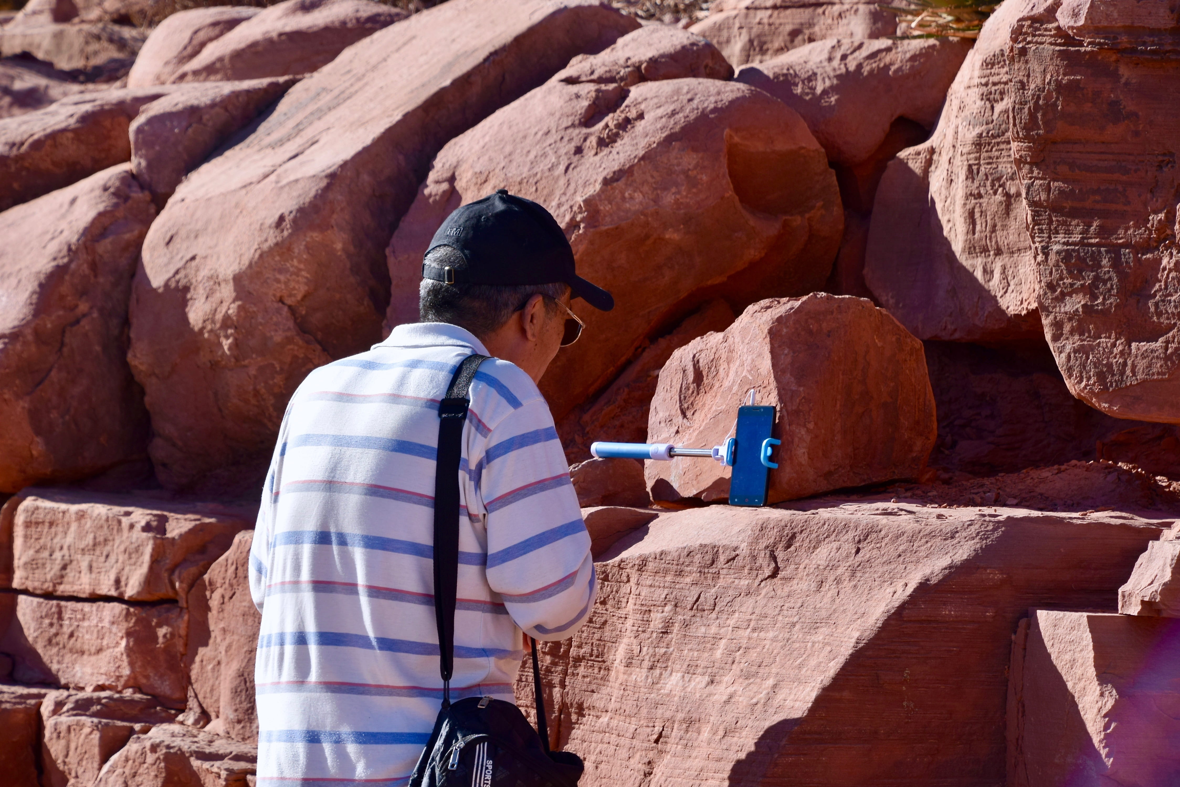 rock - object, one person, three quarter length, real people, stones, day, dusty, men, nature, rear view, talking, selfie stick, young adult, sunlight, HD Wallpaper
