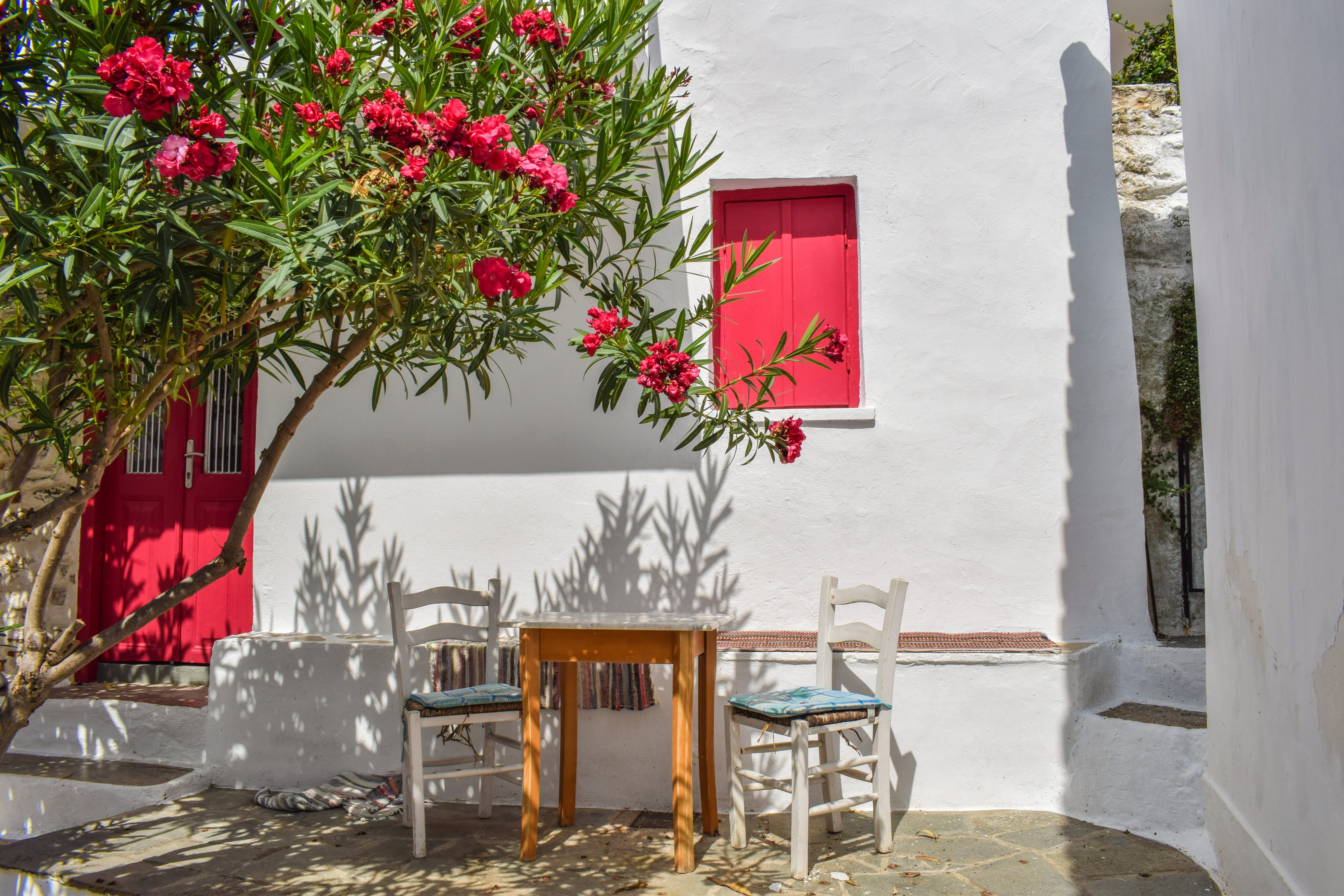 bistro, mediterranean, greece, 5K, red, table, white, furniture, chora, piece, architecture, house, building, brown, outdoor chair, flowering plant, nature, HD Wallpaper