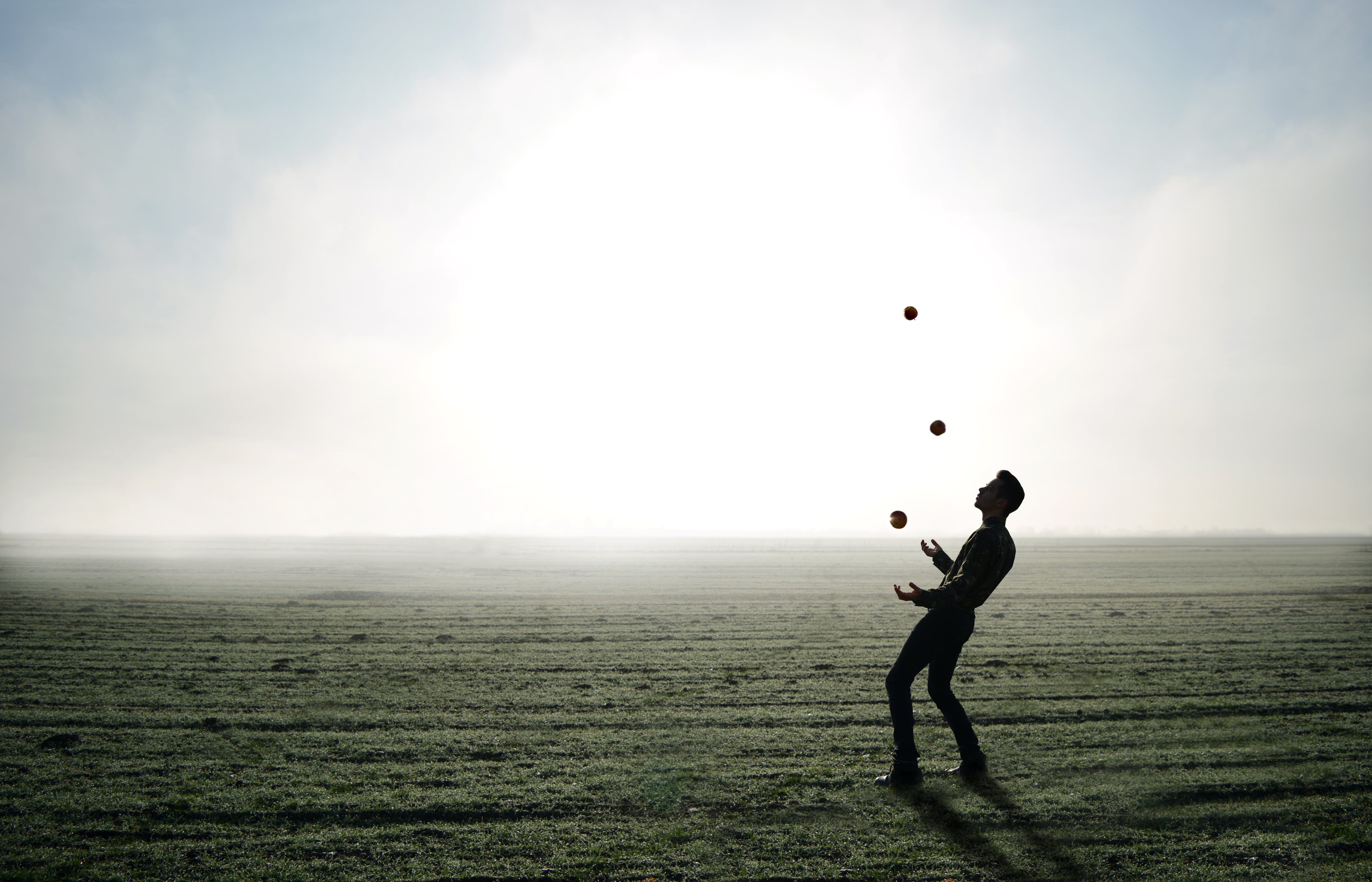 full length, one person, outdoor, leisure activity, lifestyles, grass, outdoors, silhouette, clear, juggler, man, field, apple, juggling, nature, land, HD Wallpaper