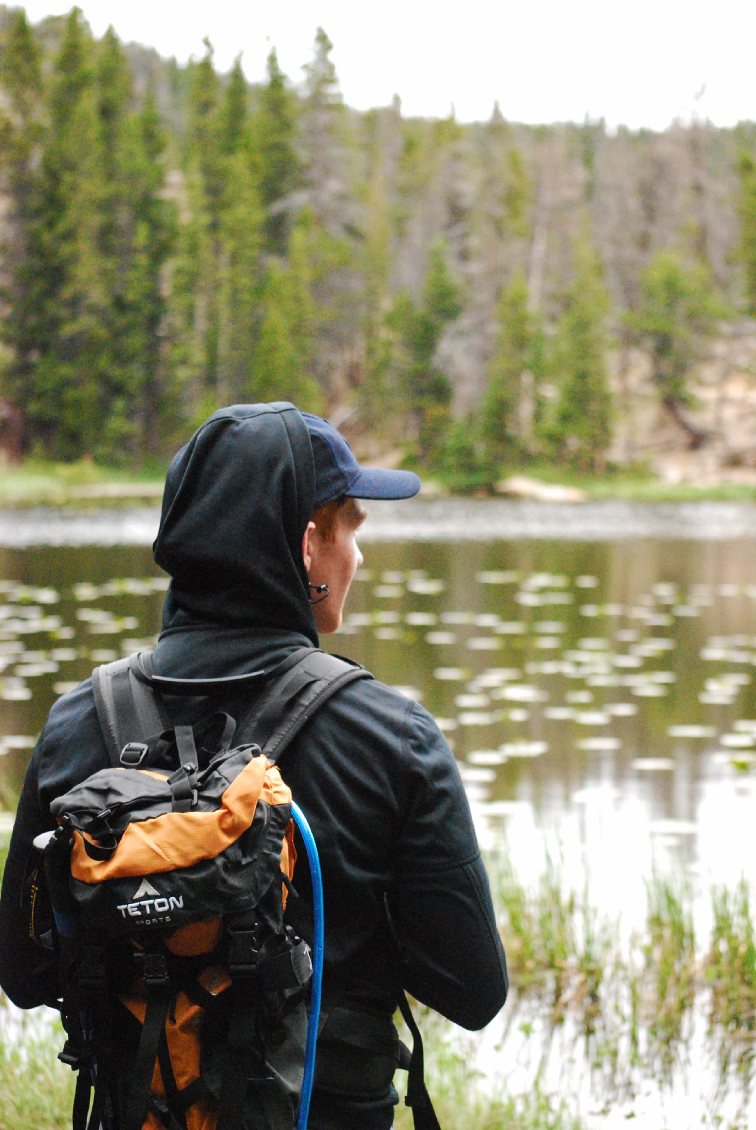 person, bag, standing, leisure activity, adventure, day, real people, focus on foreground, outdoors, hood, human, backpack, lake, nature, coat, lifestyles, Phone HD Wallpaper