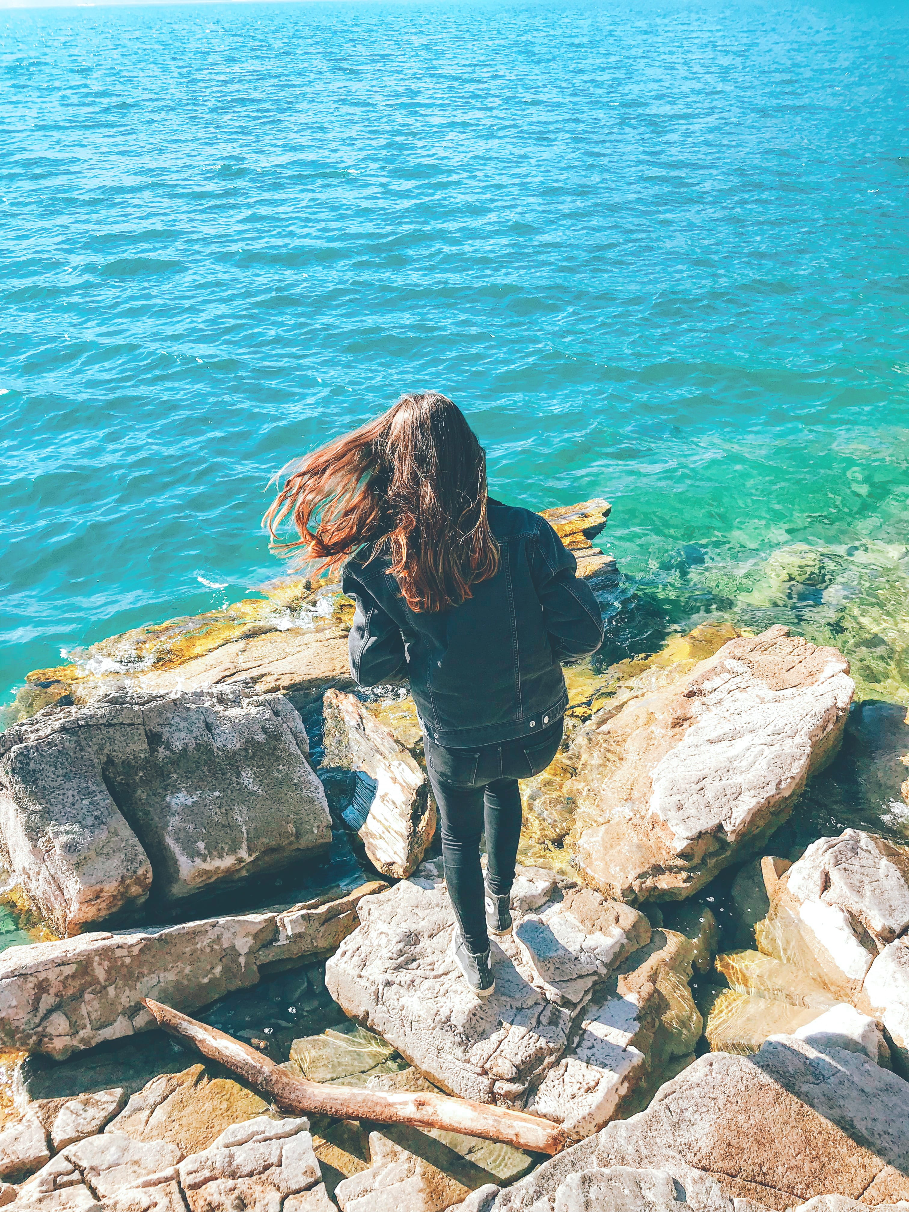 summer, peaceful, ripples, hairstyle, scenic, day, female, lifestyles, brunette, casual clothing, body, young adult, one person, rock, 4K, seascape, seashore, Phone HD Wallpaper
