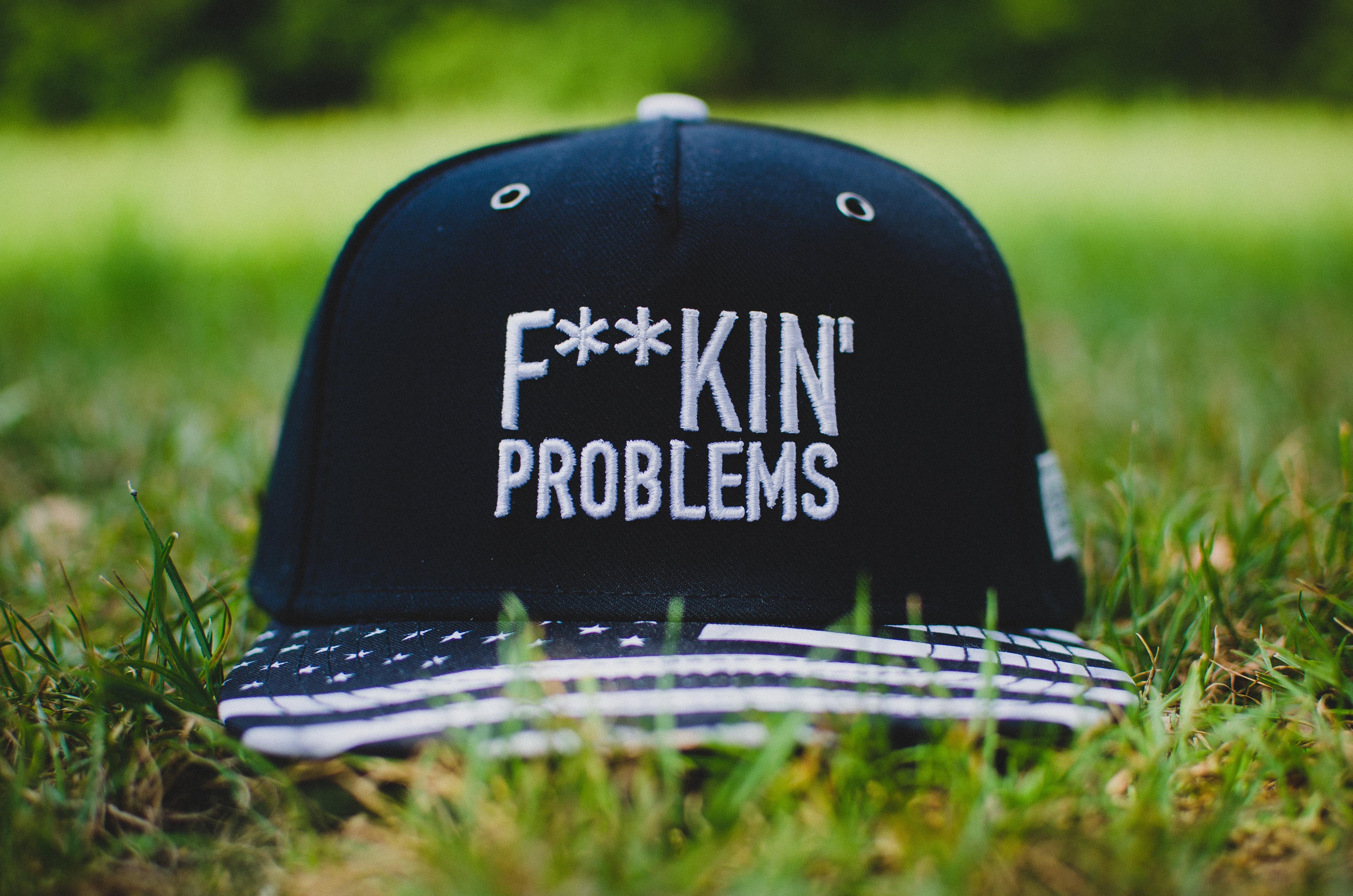 stone, communication, text, black, snapback, black color, grass, 4K, cap, plant, selective focus, wireless technology, close-up, day, ceremony, baseball caps, HD Wallpaper
