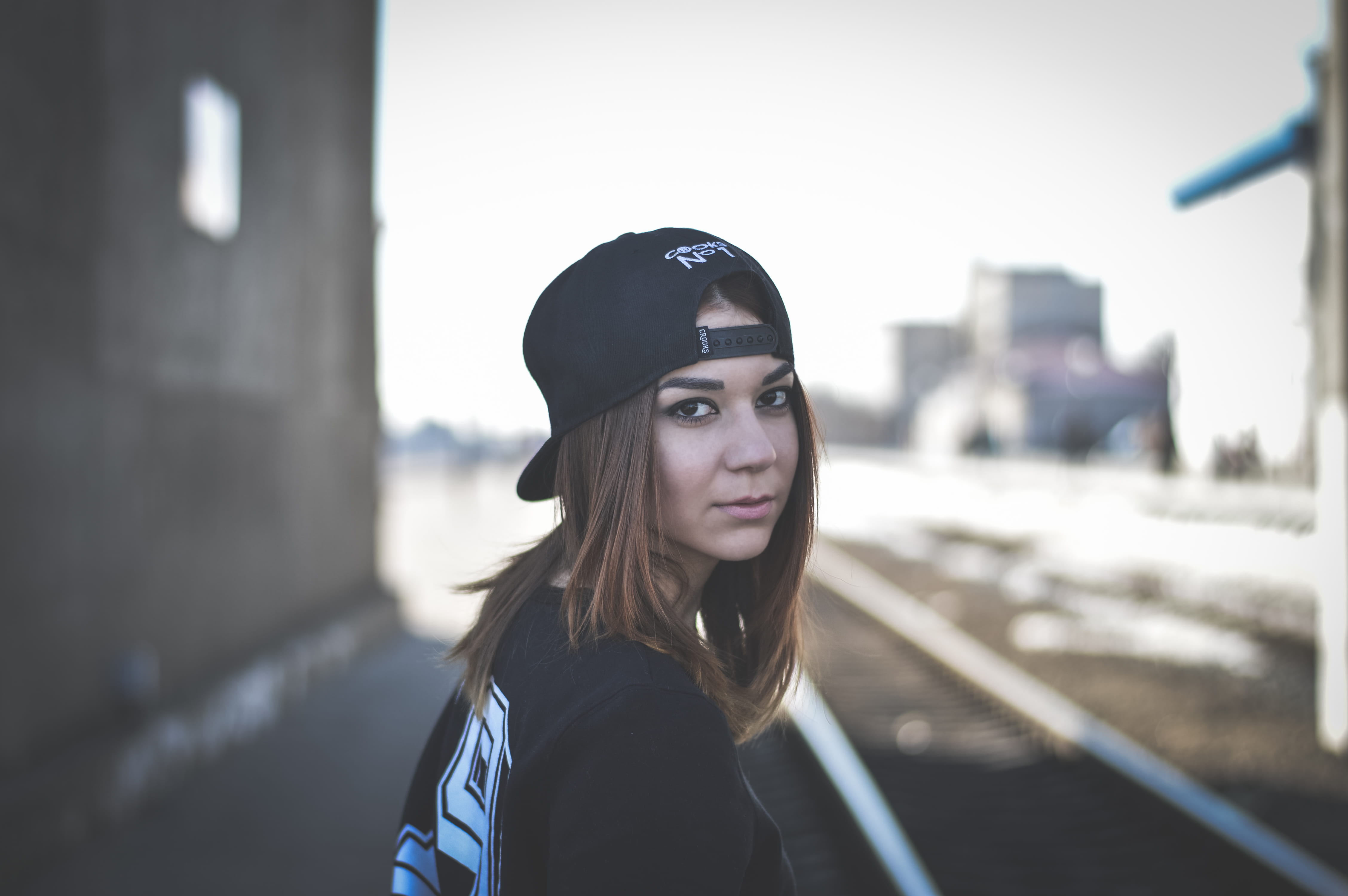 wearing, girl, standing, face, young women, 4K, city, selective, day, focus on foreground, one person, factory, beautiful woman, outdoors, cap, looking, HD Wallpaper