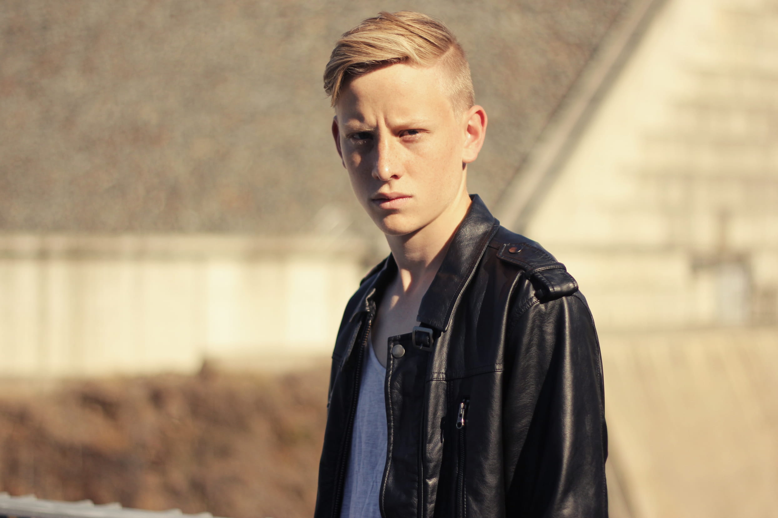 focus, architecture, day, 1080P, standing, young adult, serious, jacket, leather, one person, photography, hairstyle, black, frown, looking at camera, HD Wallpaper