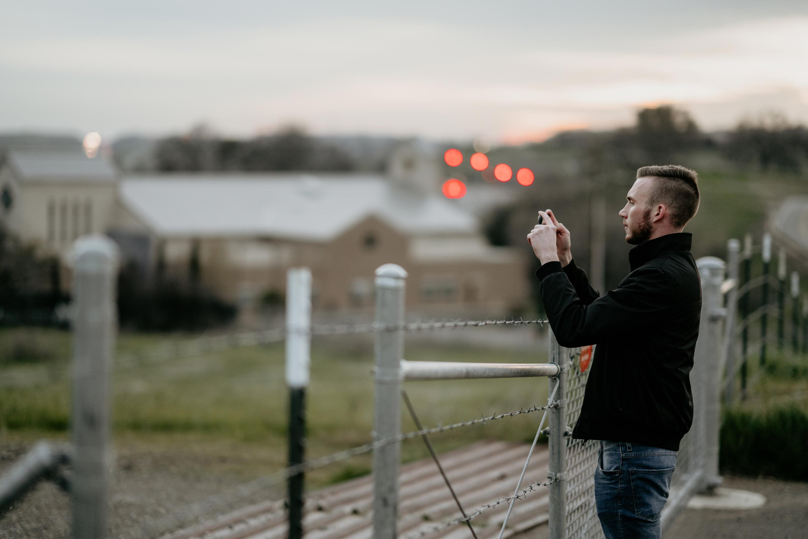 shallow, one person, hand, adult, barbed wire, lights, architecture, smartphone, photo, three quarter length, bokeh, focus, sunset, taking, iphone photography, HD Wallpaper