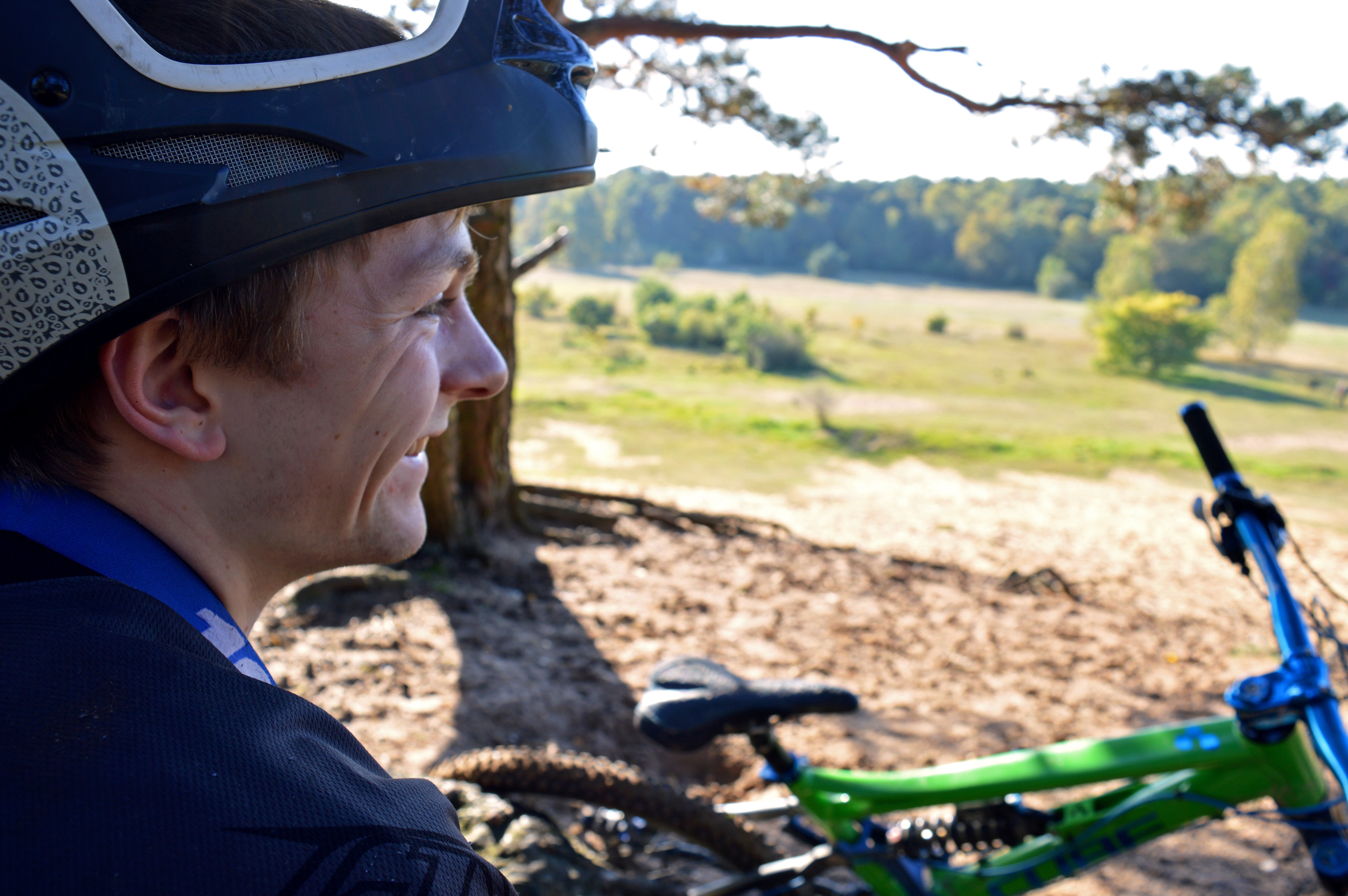 hobby, meadow, men, focus on foreground, riding, helm, sun, emotion, sport, sunlight, green, creative skills, eyes, bicycle, cheerful, background, nature, HD Wallpaper