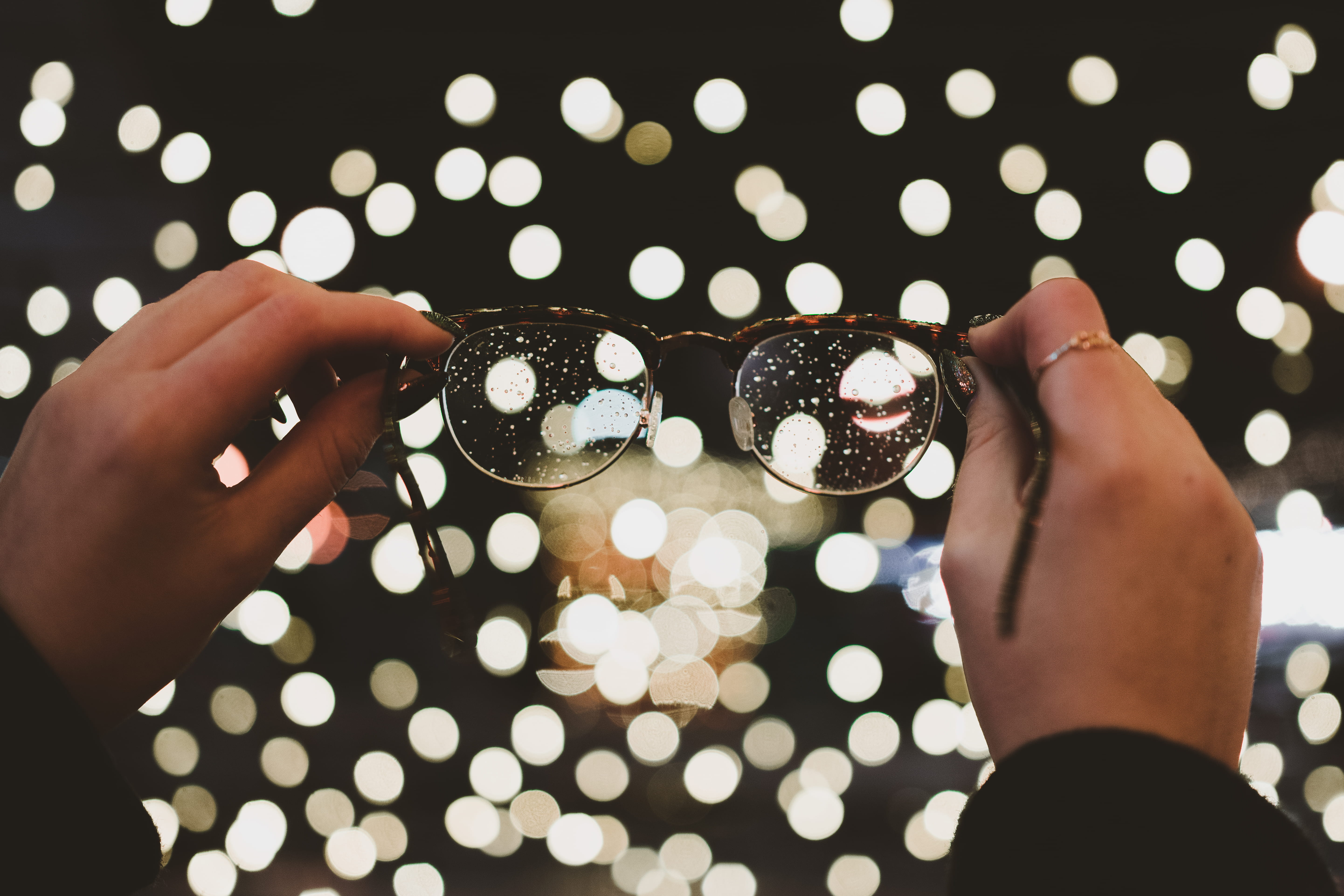 lens, real people, front, close-up, human hand, bokeh, human body part, lights, 5K, lifestyles, hand, adult, glasses, eyeglasses, boke, holding, food and drink, HD Wallpaper