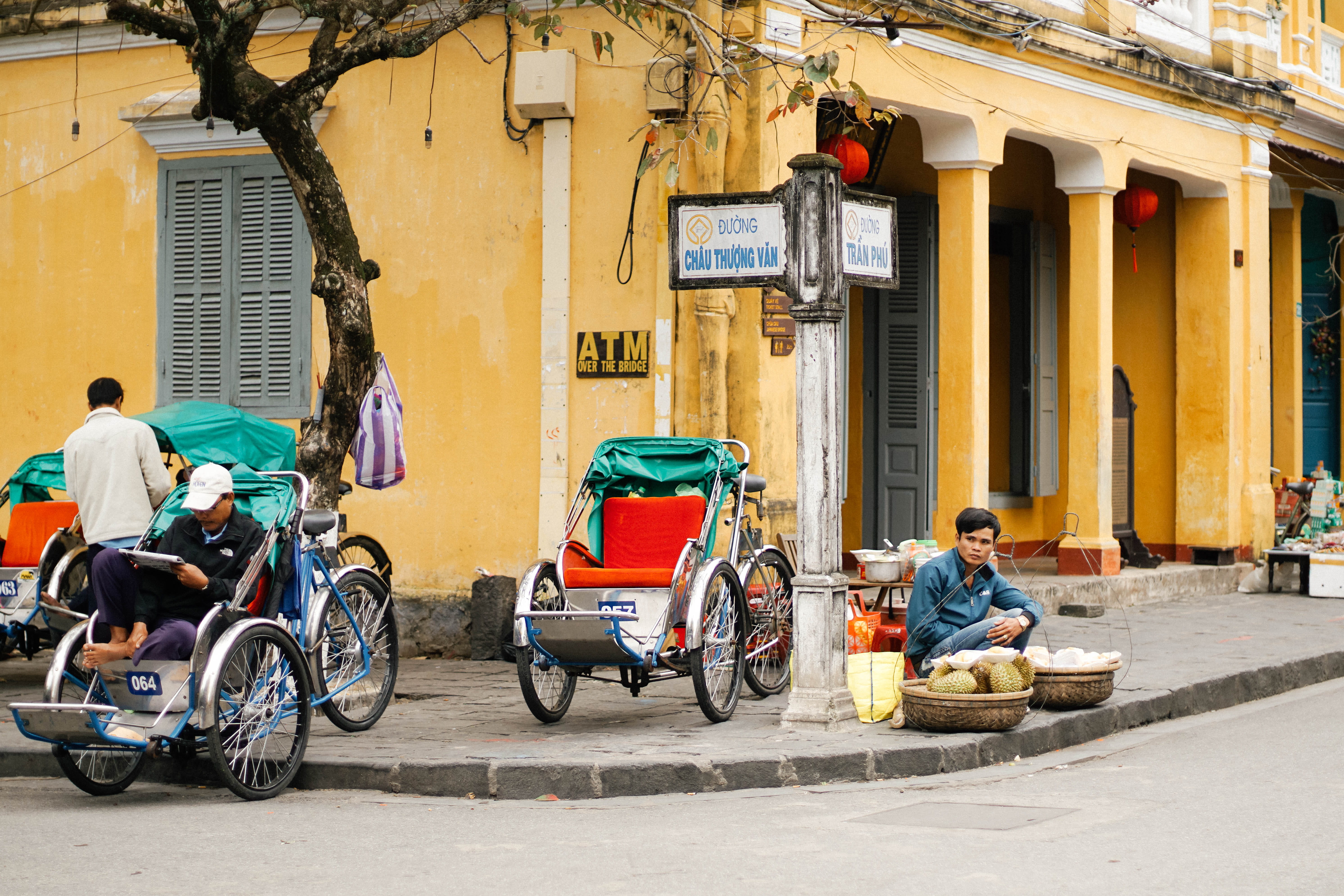 people, trike, yellow, front, street sign, city life, city, red, mode of transportation, cart, sitting, road, rickshaw, land vehicle, cityscape, architecture, HD Wallpaper