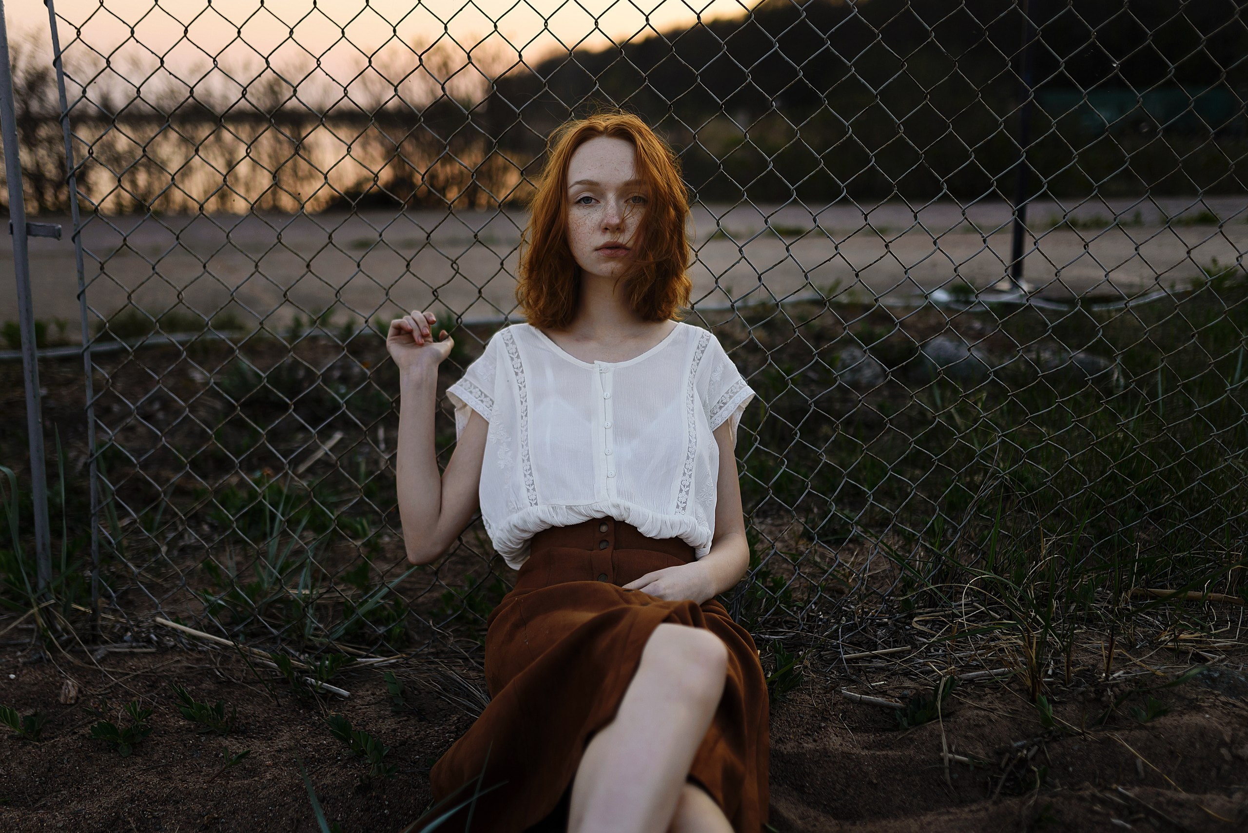 looking at viewer, women outdoors, day, redhead, one person, blouses, 2K, sitting, hairstyle, three quarter length, outdoors, women, contemplation, chainlink fence, HD Wallpaper