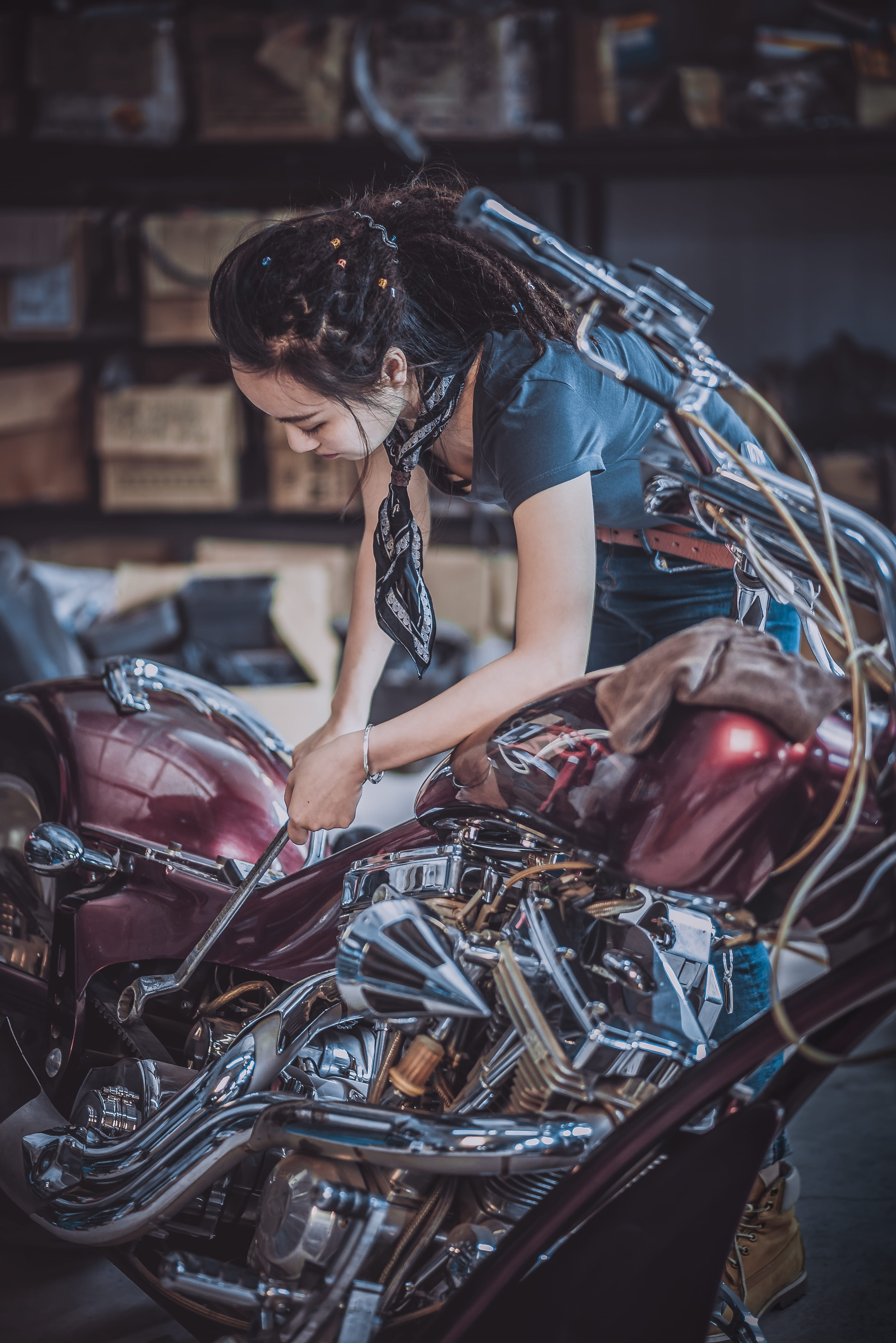 motorcycle, young adult, women, indoors, garage, repairing, lady, real people, hairstyle, dark, lifestyles, adult, three quarter length, female, red, sitting, Phone HD Wallpaper
