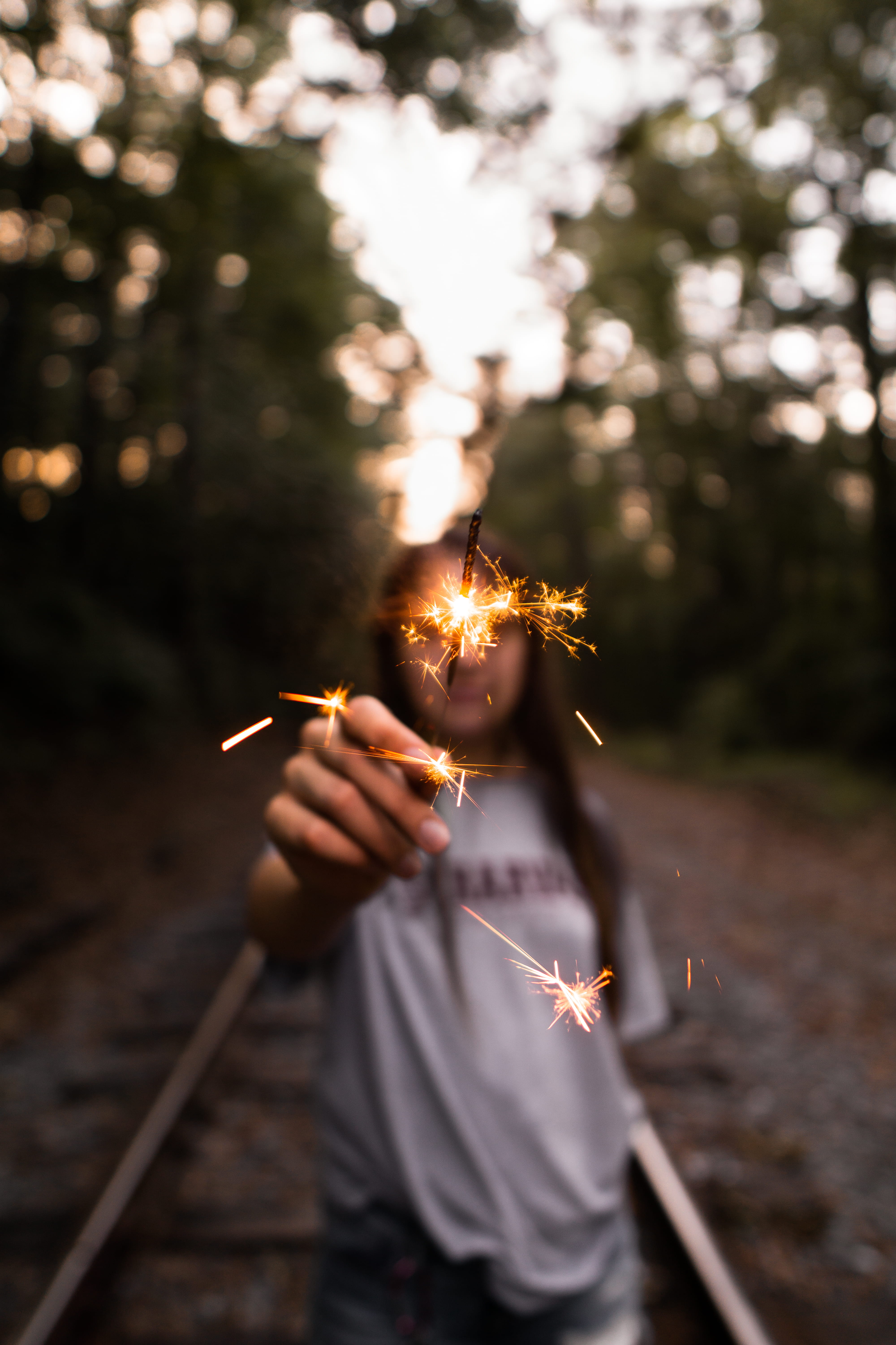 selective, mood, sparks, moody, abandoned railroad, forest, fire, motion, focus on foreground, detail, firework - man made object, closeup, nature, human hand, Phone HD Wallpaper