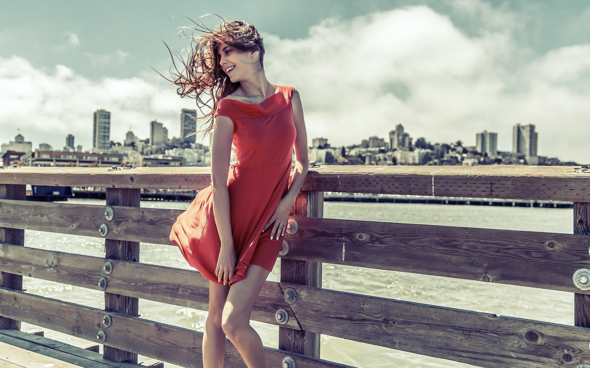 cityscape, 1080P, windy, women, red dress, brunette, dress, legs, smiling, city, HD Wallpaper
