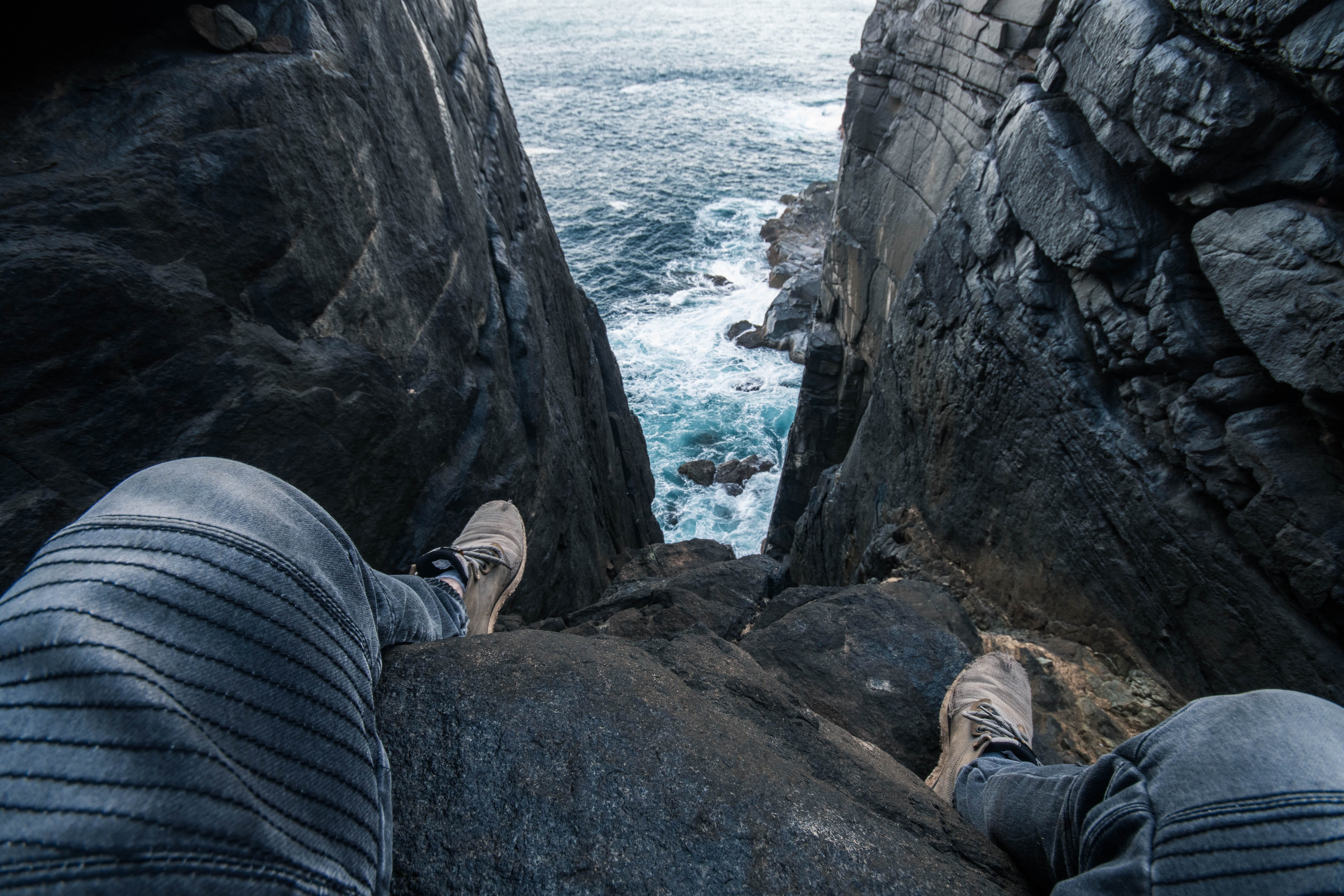 clothing, cliff, gray, day, low section, leisure activity, human leg, limestone, human foot, sea, jeans, rock, slate, wearing, nature, rock - object, ocean, HD Wallpaper