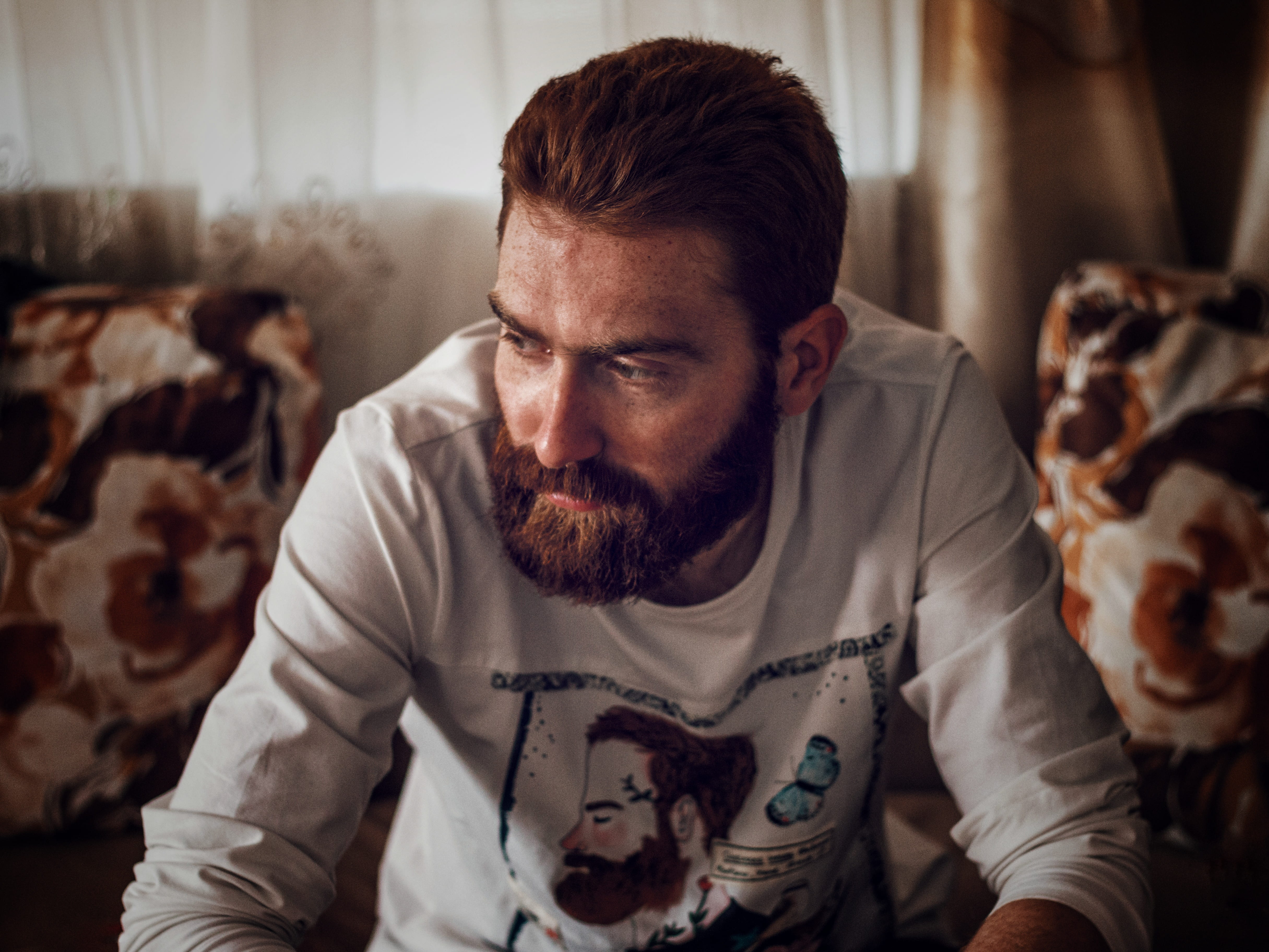 fashion, front view, sitting, adult, wearing, sofa, shirt, waist up, sideways, curtain, males, man, beard, mustache, facial hair, male, domestic animals, HD Wallpaper