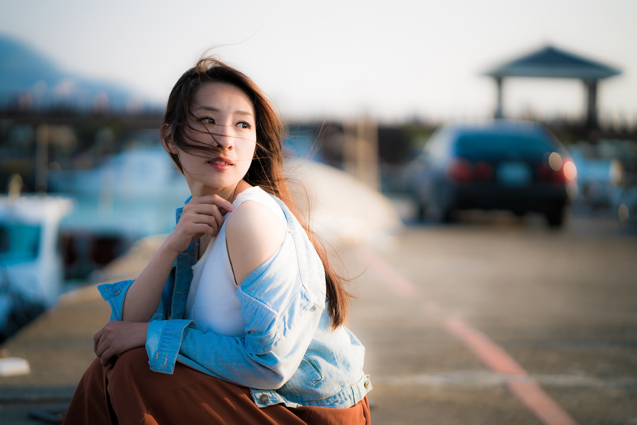 teenager, young adult, focus on foreground, real people, model, outdoors, beautiful woman, tank top, long hair, sitting, jeans jacket, casual clothing, HD Wallpaper