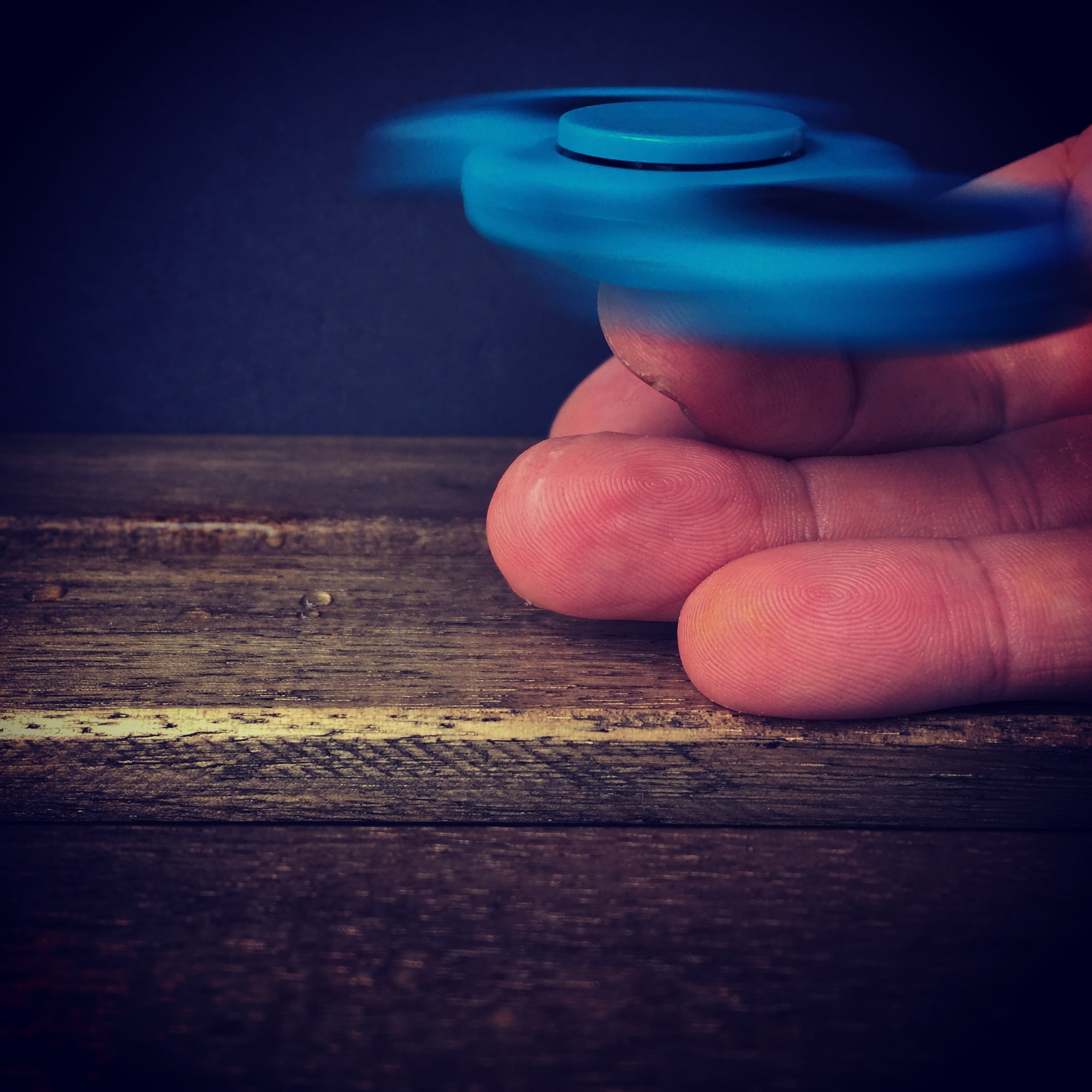 human finger, close-up, lifestyles, food and drink, blue, wood, real people, table, playing, enjoyment, plastic, light, toy, wooden, hand, spin, modern, Phone HD Wallpaper