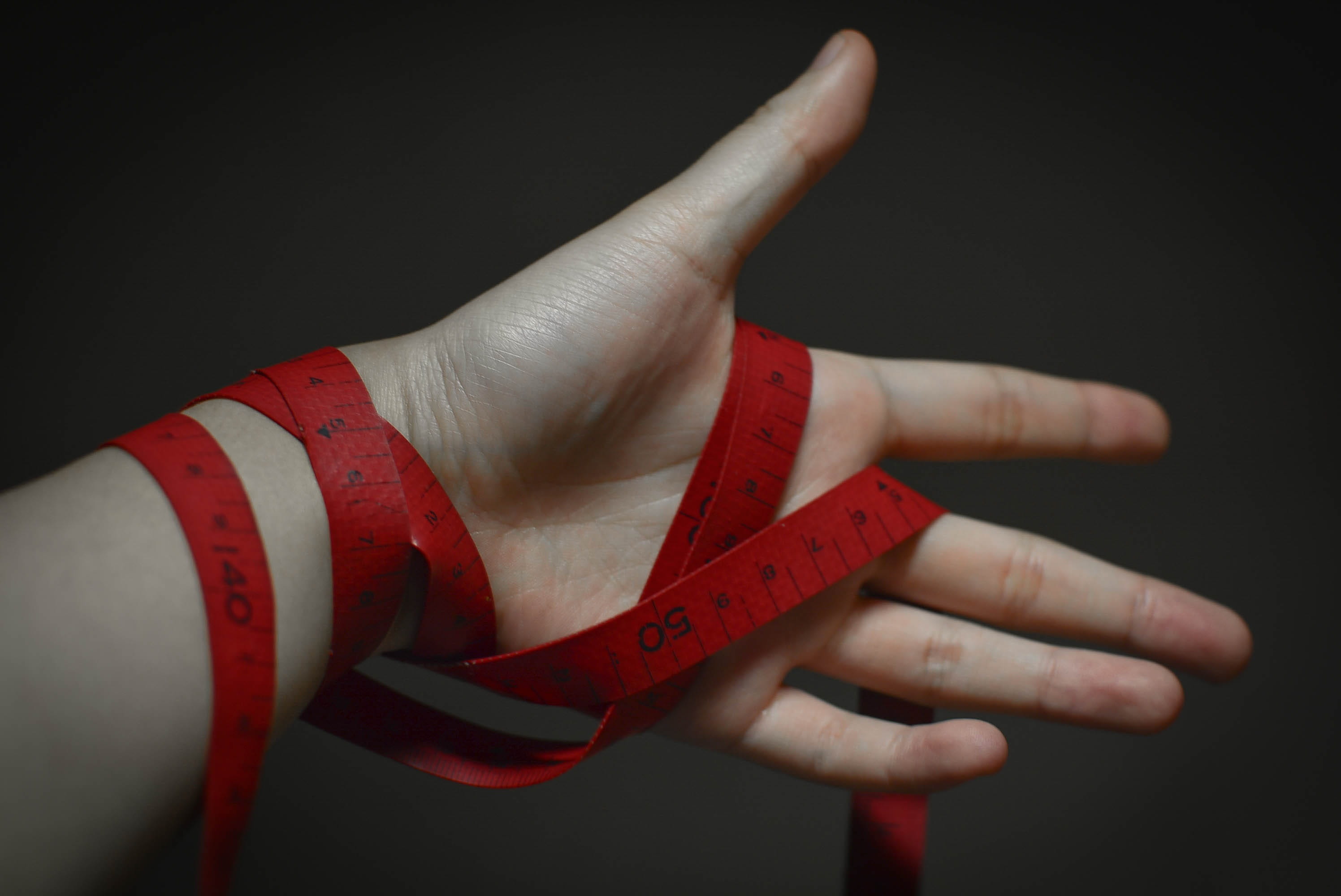 young adult, people, holding, Body, Darkness, finger, Tape, gesturing, close-up, women, line, red, adhesive tape, measure, black background, men, communication, HD Wallpaper