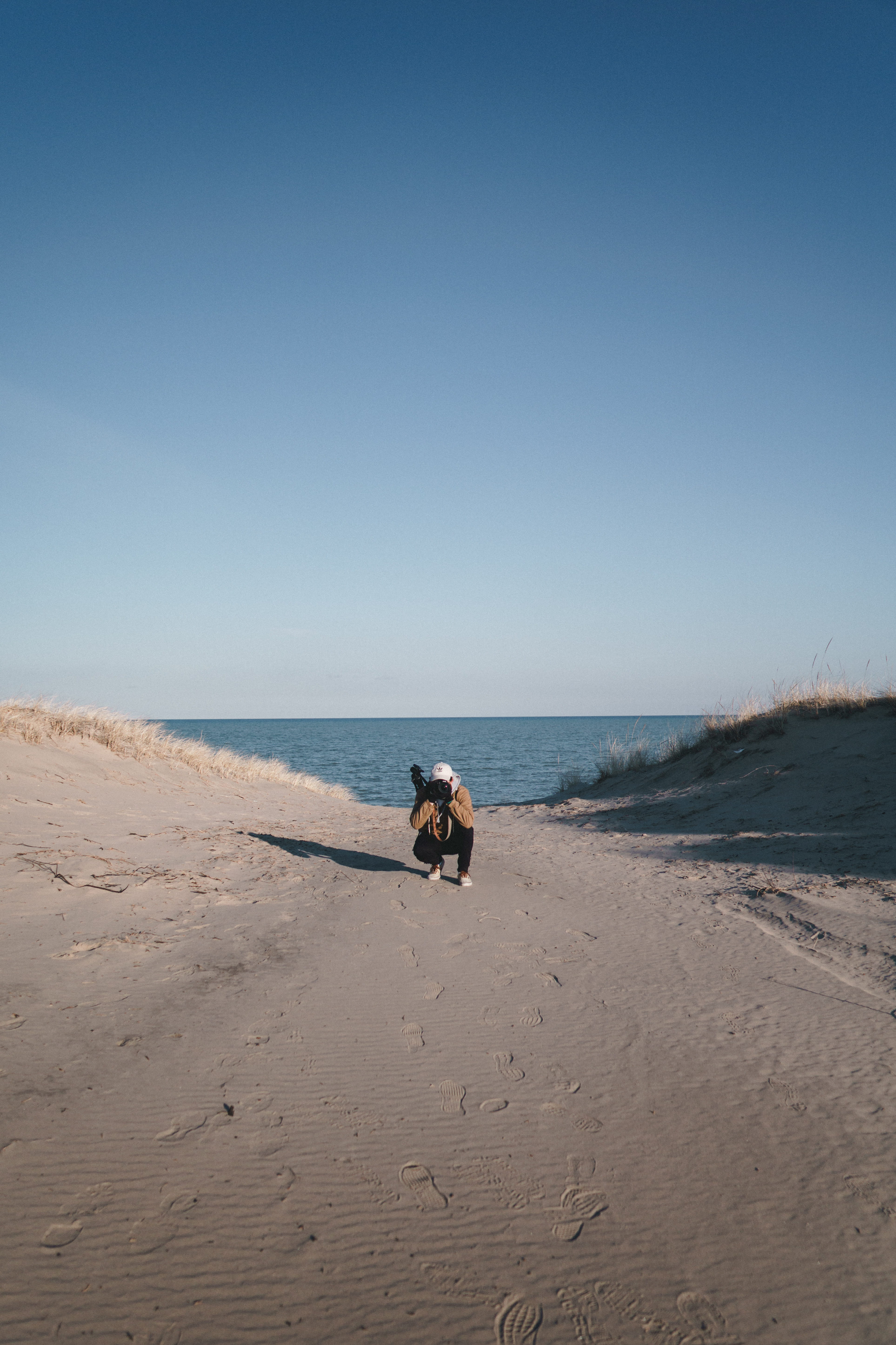 sand, photographer, pet owner, brown, pets, jacket, path, white, camera, nature, 5K, walking, shoes, full length, horizon, land, crouch, gradient, taking photo, Phone HD Wallpaper