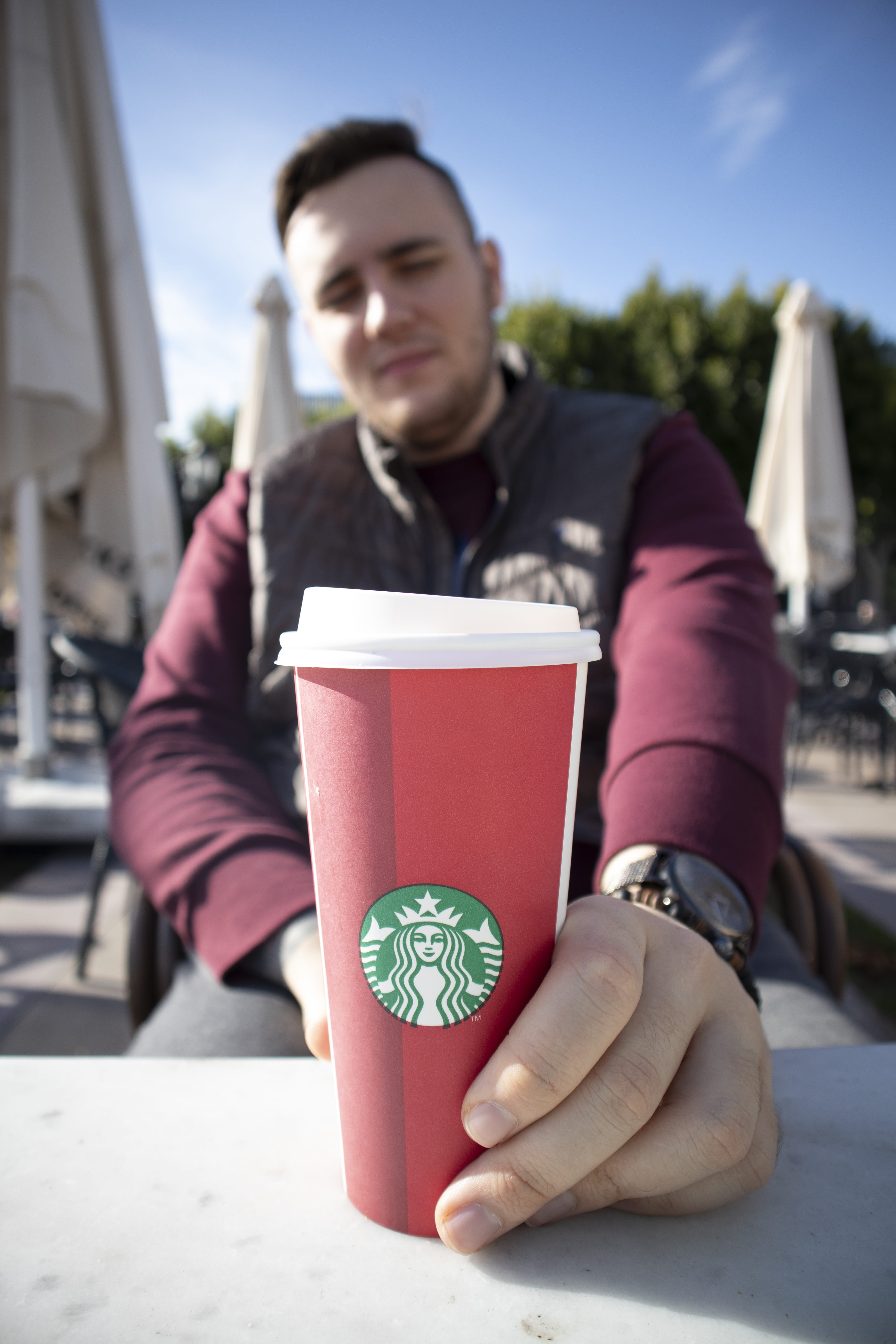 sunlight, table, outdoors, cup, starbucks, sweater, focus on foreground, finger, males, real people, cafe, casual clothing, bottle, word, beverage, person, Phone HD Wallpaper
