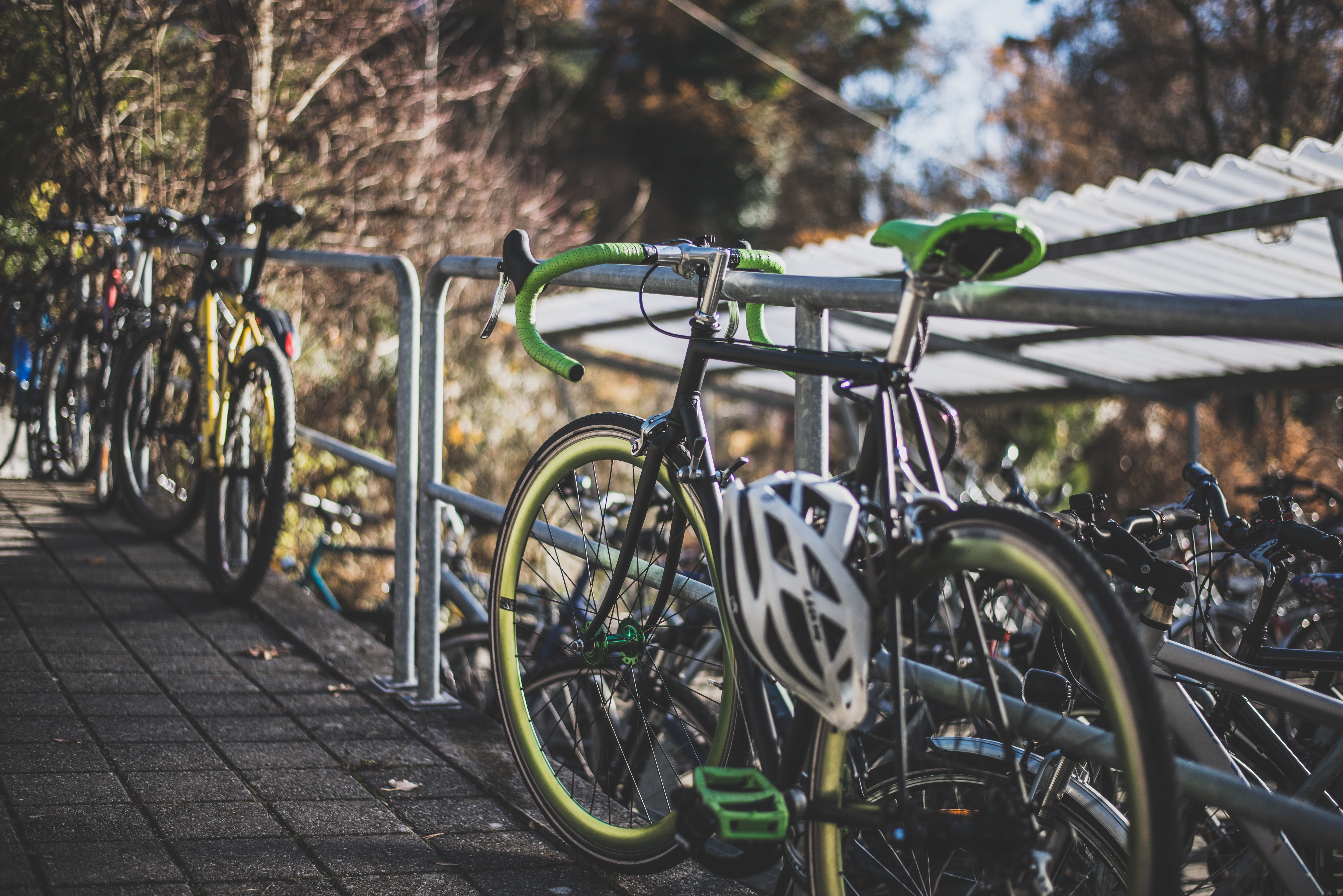 black, in a row, helmet, tree, footpath, parking, beside, green, street, mode of transport, nature, city, sport, outdoors, summer, parked, hobby, 5K, focus on foreground, HD Wallpaper