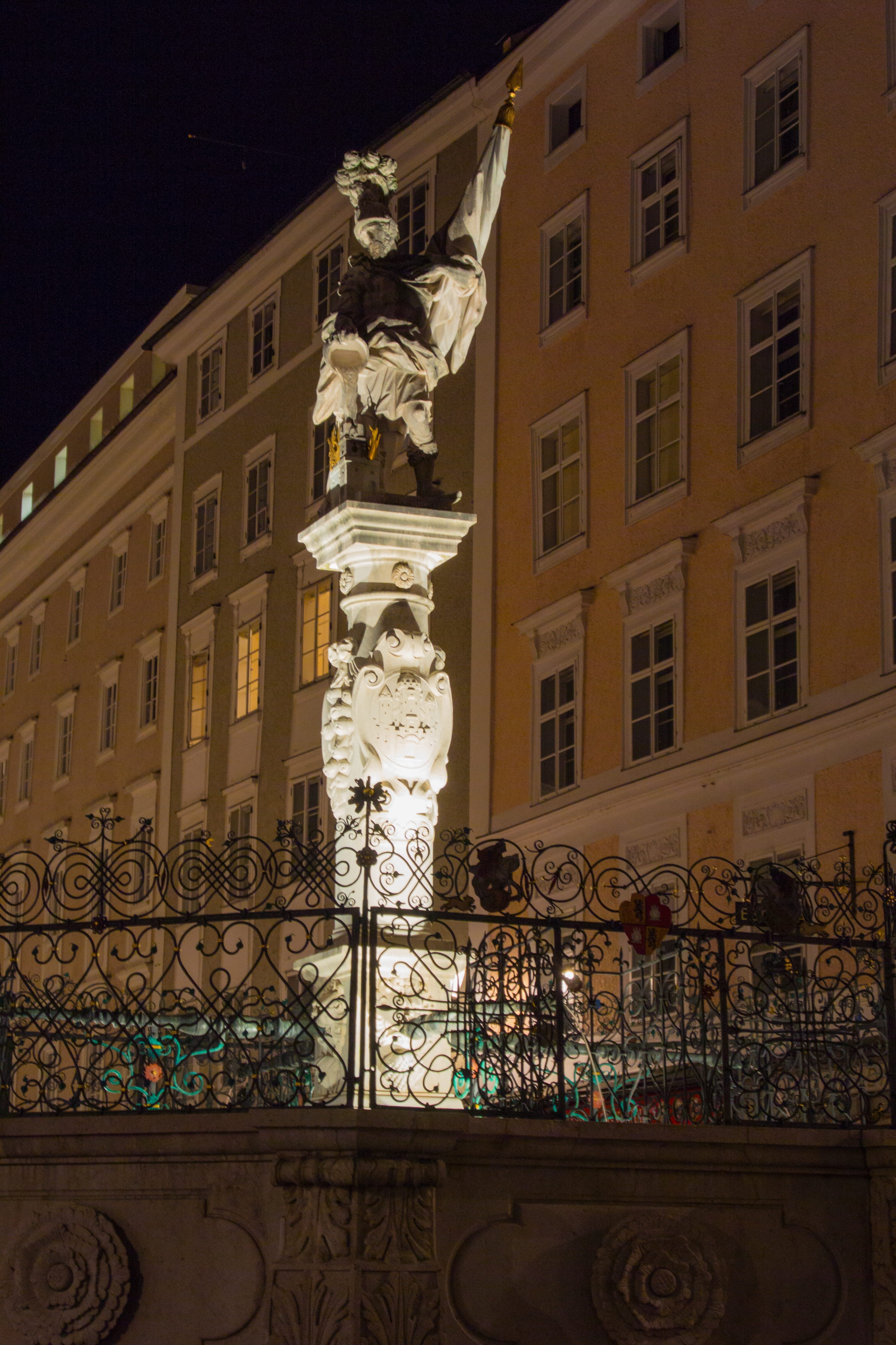 Downtown, fountain, male likeness, art and craft, city, angel, window, ornate, fountain column, city of salzburg, night, florian of lorch, Old Town, building, Phone HD Wallpaper