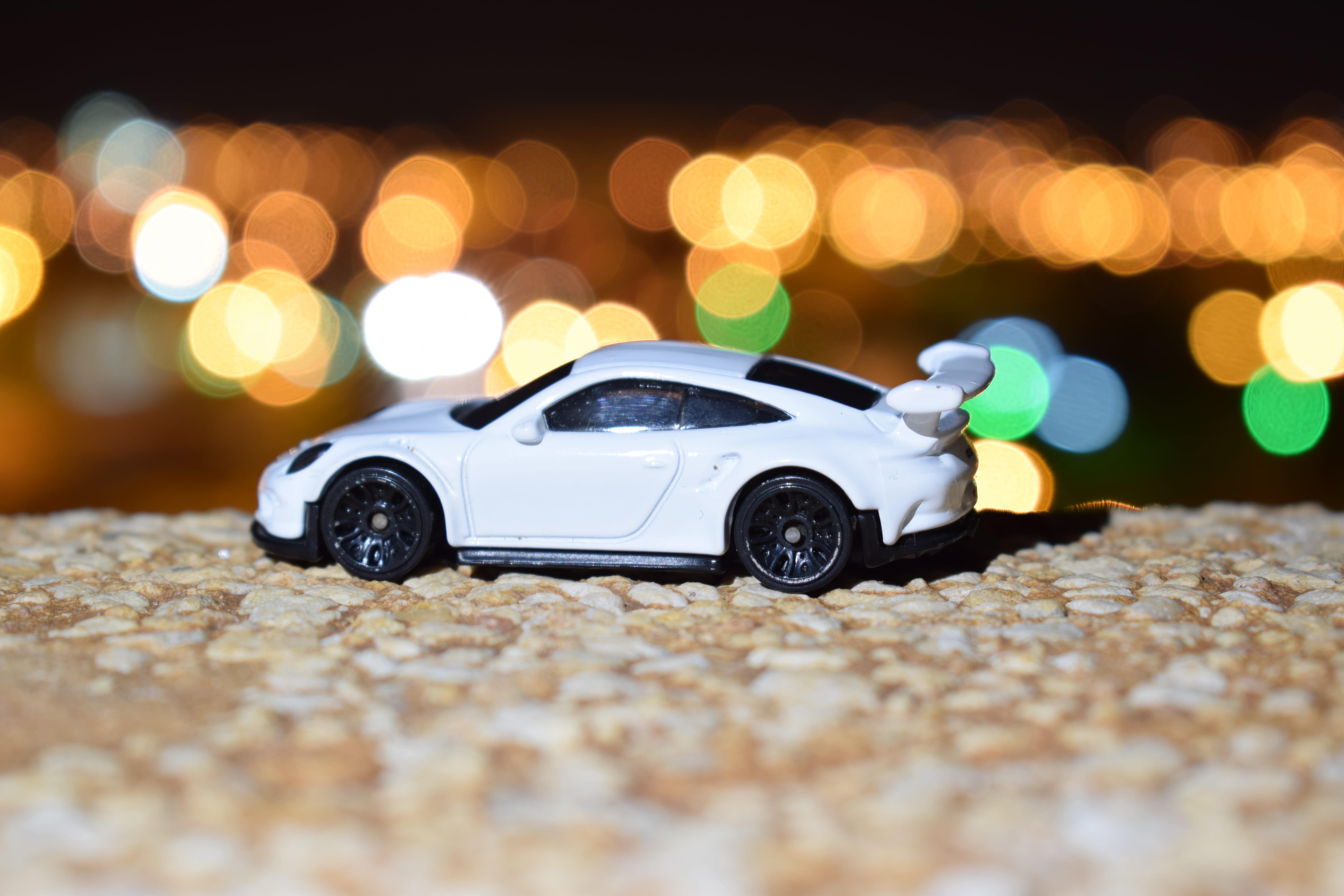 surface level, 5K, nikon, mobil, no people, night, shiny, modern, lamp, ksa, toy, toys, road, hotwheles, blur, close-up, street, defocused, toy car, white, HD Wallpaper
