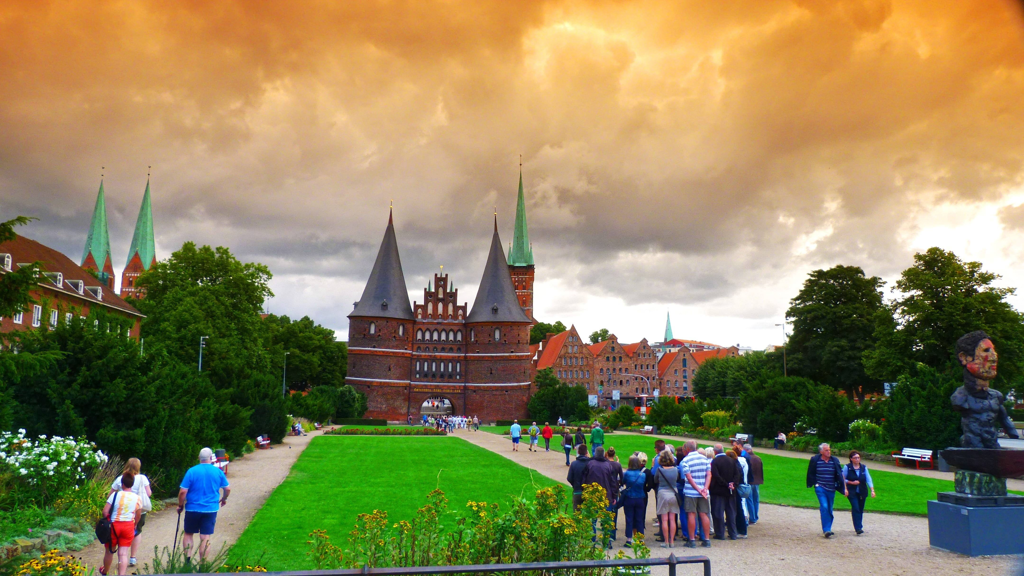 grass, lübeck, the past, nature, landmark, building, cloud - sky, city gate, crowd, real people, group of people, plant, men, building exterior, history, HD Wallpaper